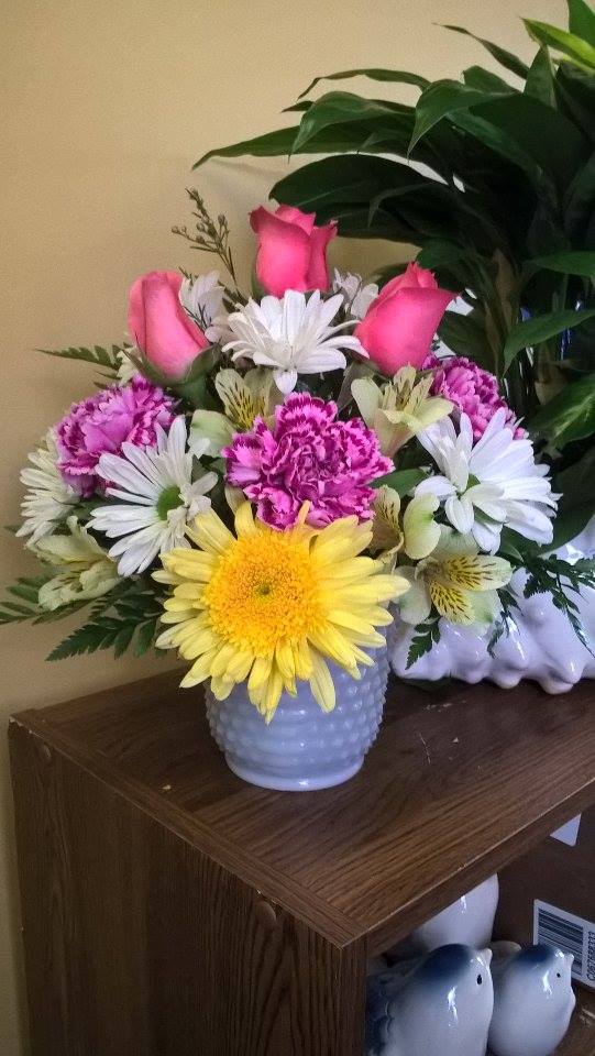 Bouquet of pink roses, daisies, and carnations in a white vase