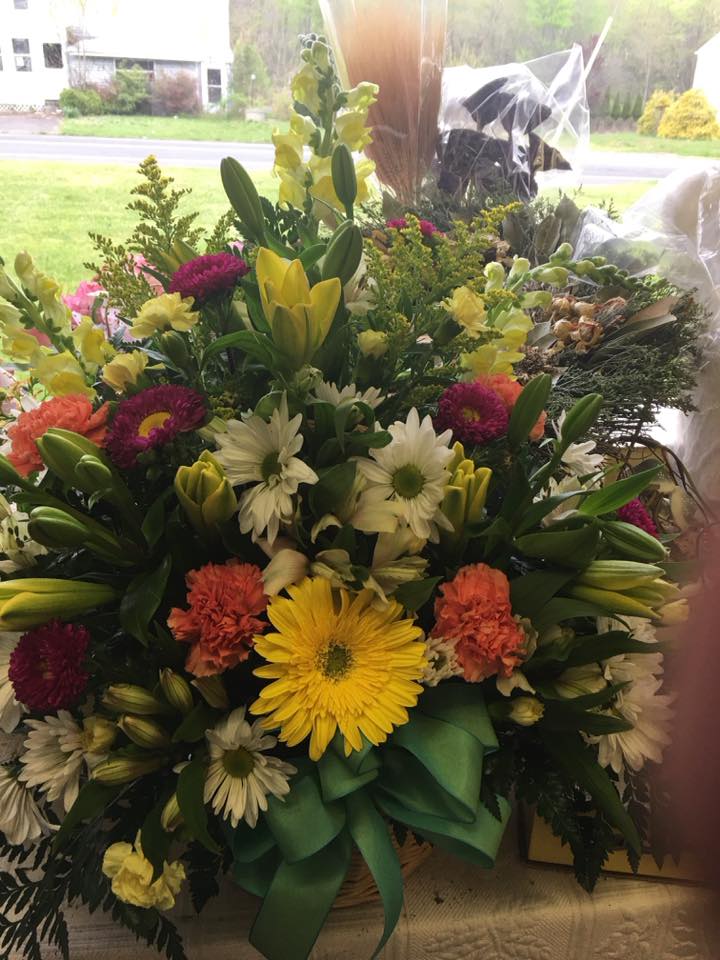 Mixed bouquet with lilies, daisies, and carnations in a basket