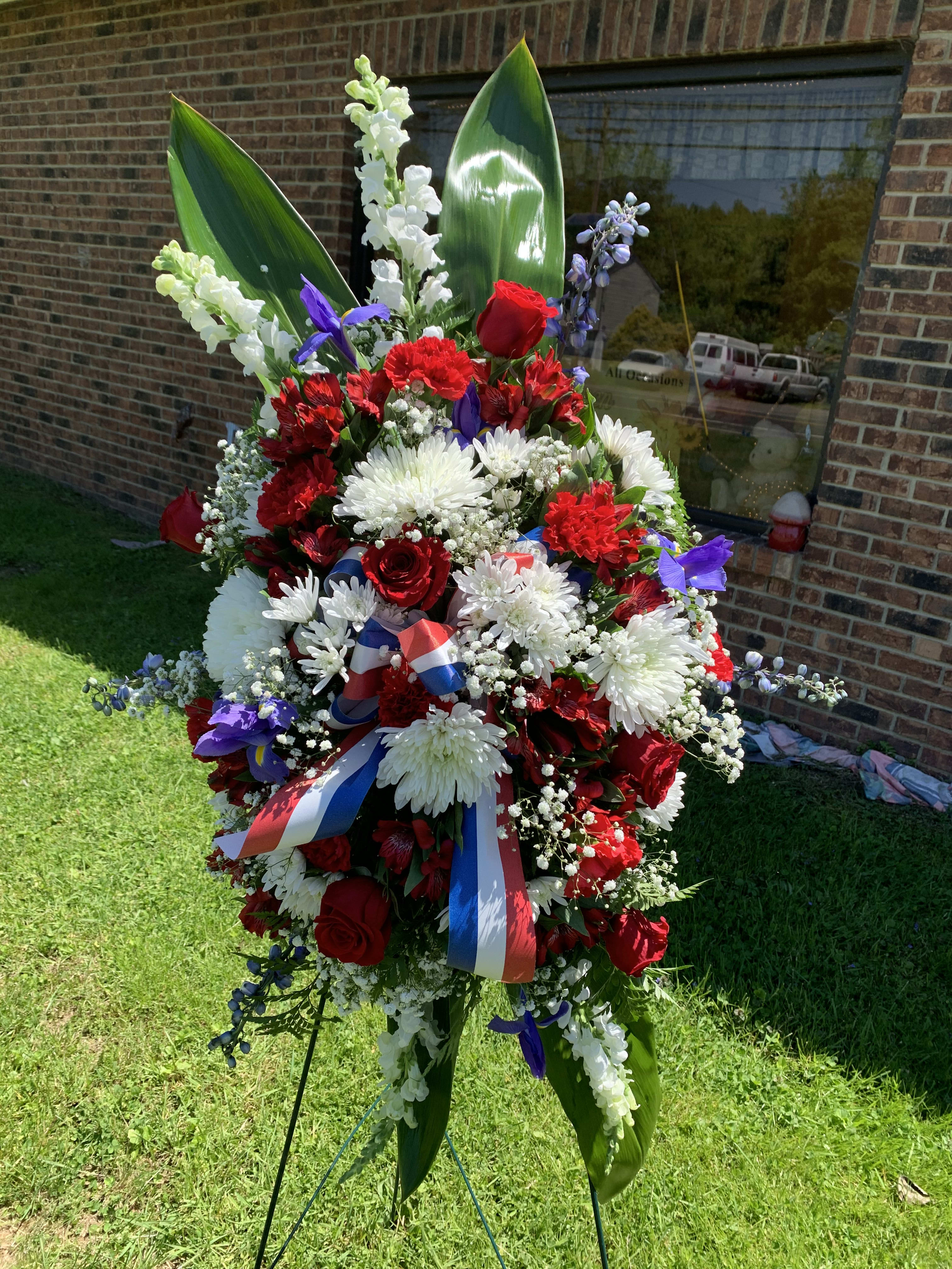 Large standing floral spray with red, white, and purple flowers