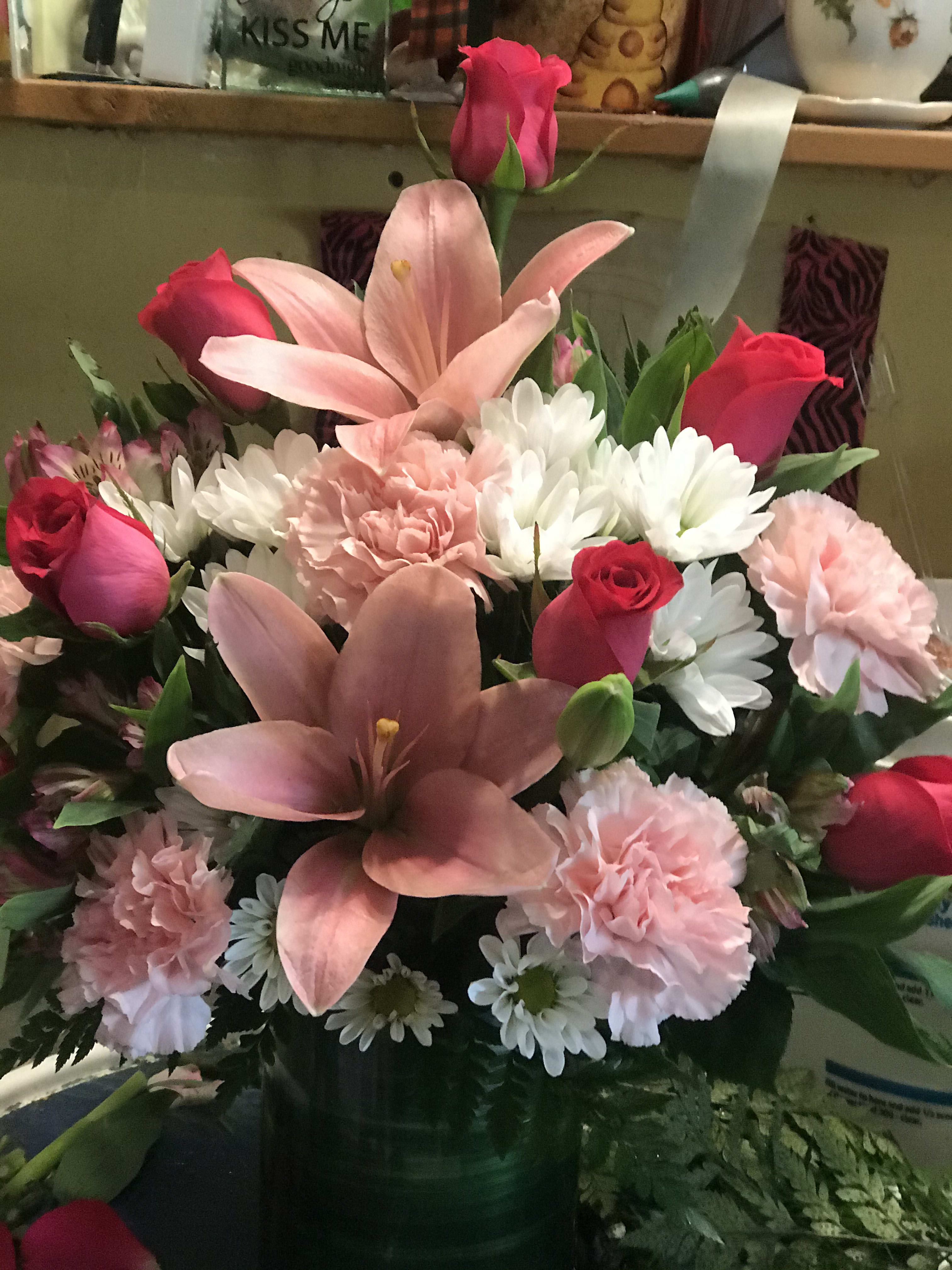 Pink lilies, roses, carnations, and white daisies in a vase