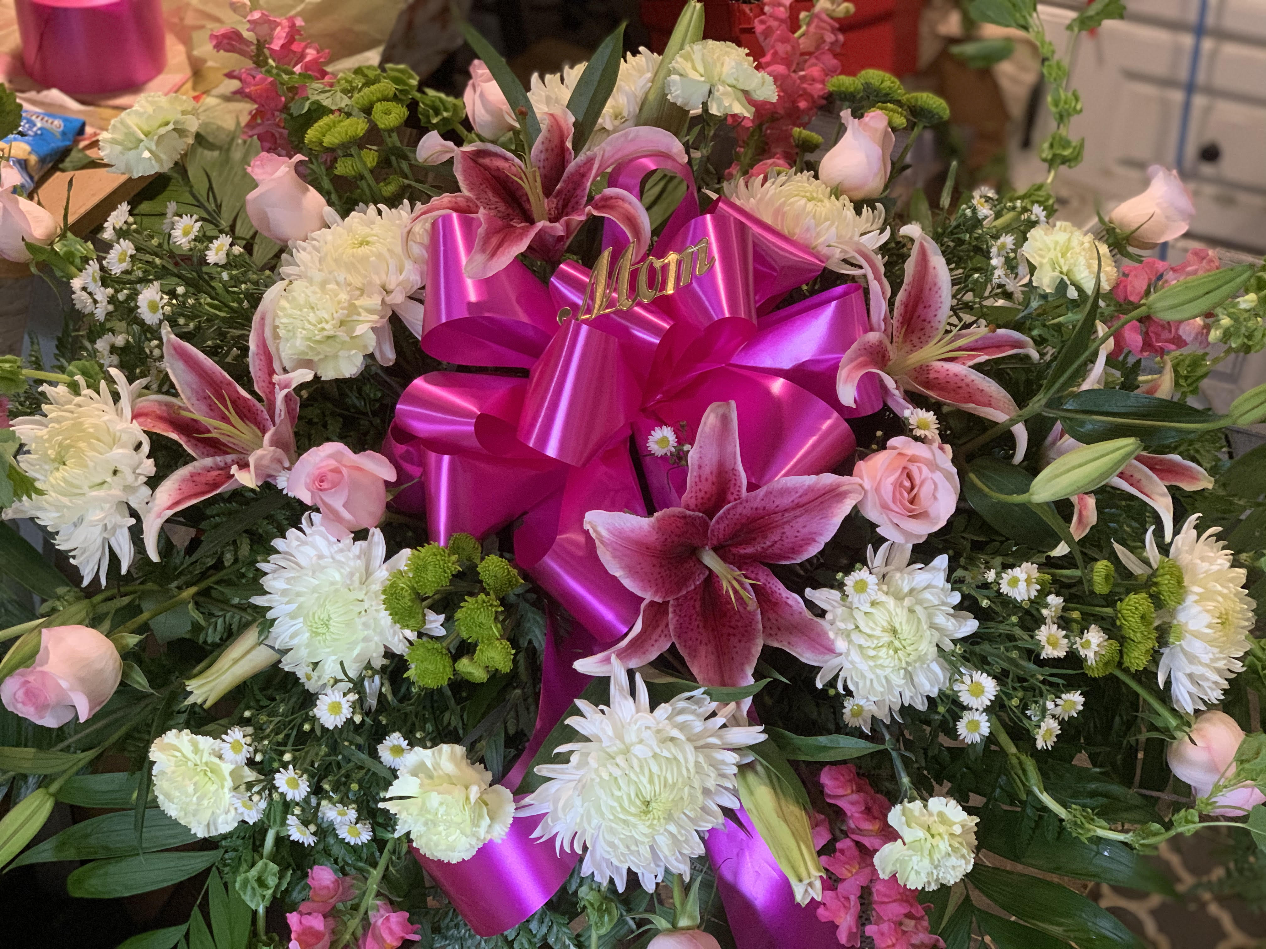 Pink and white floral arrangement with a bright magenta ribbon bow