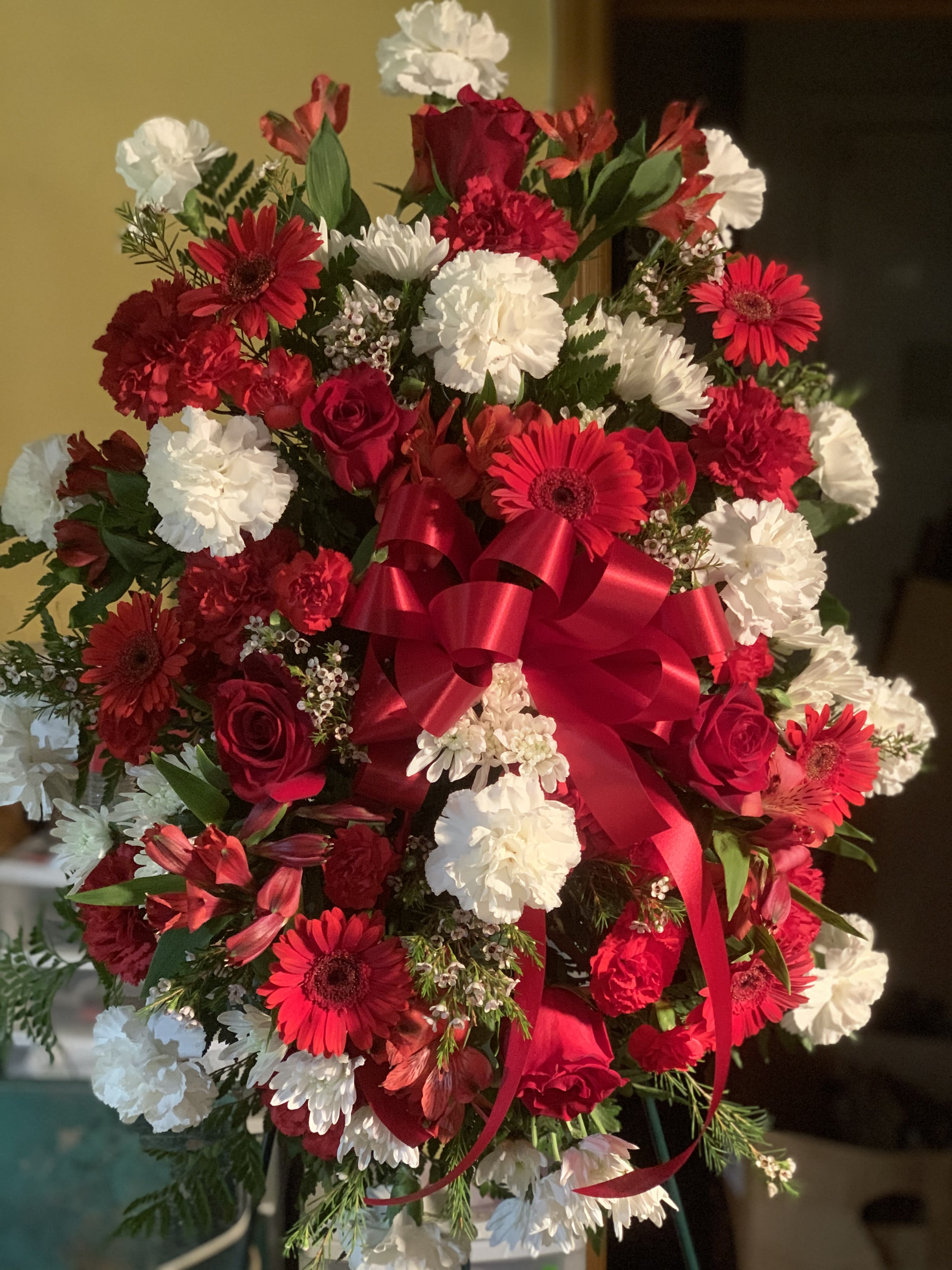 Large bouquet of red and white flowers with a red ribbon