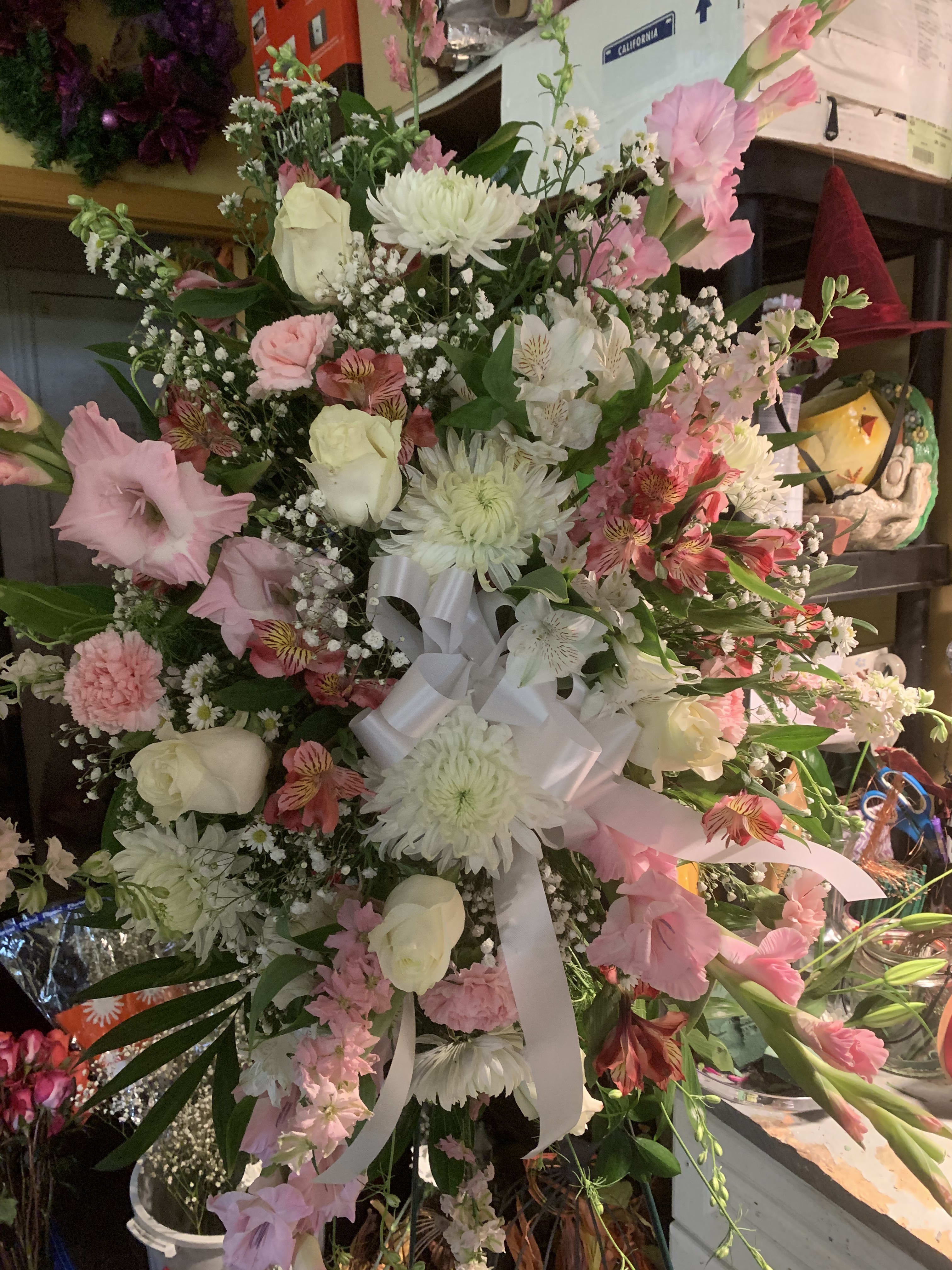 Large pink and white floral spray with a white ribbon bow