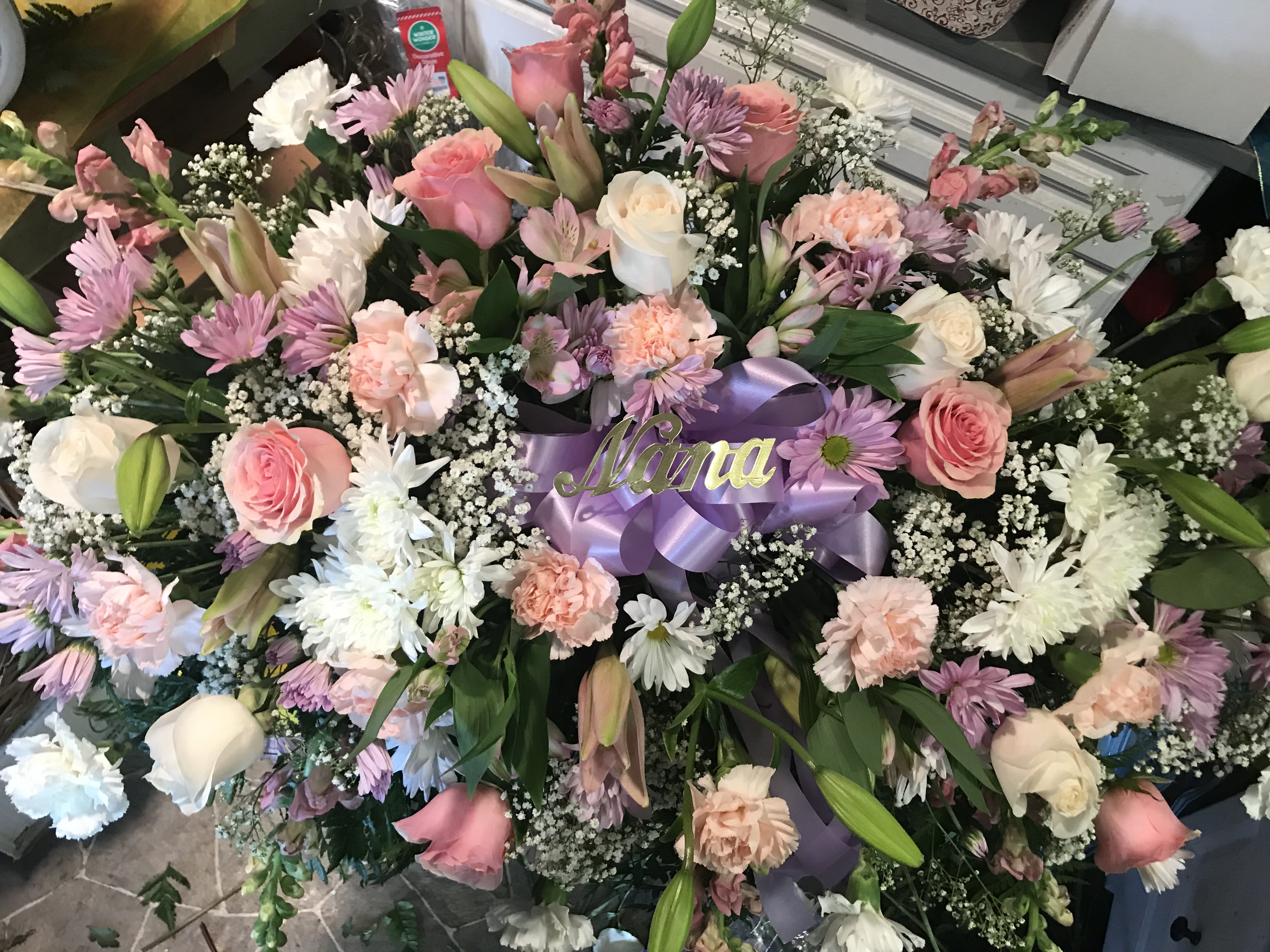 Large floral spray with pink and white roses, daisies, and carnations