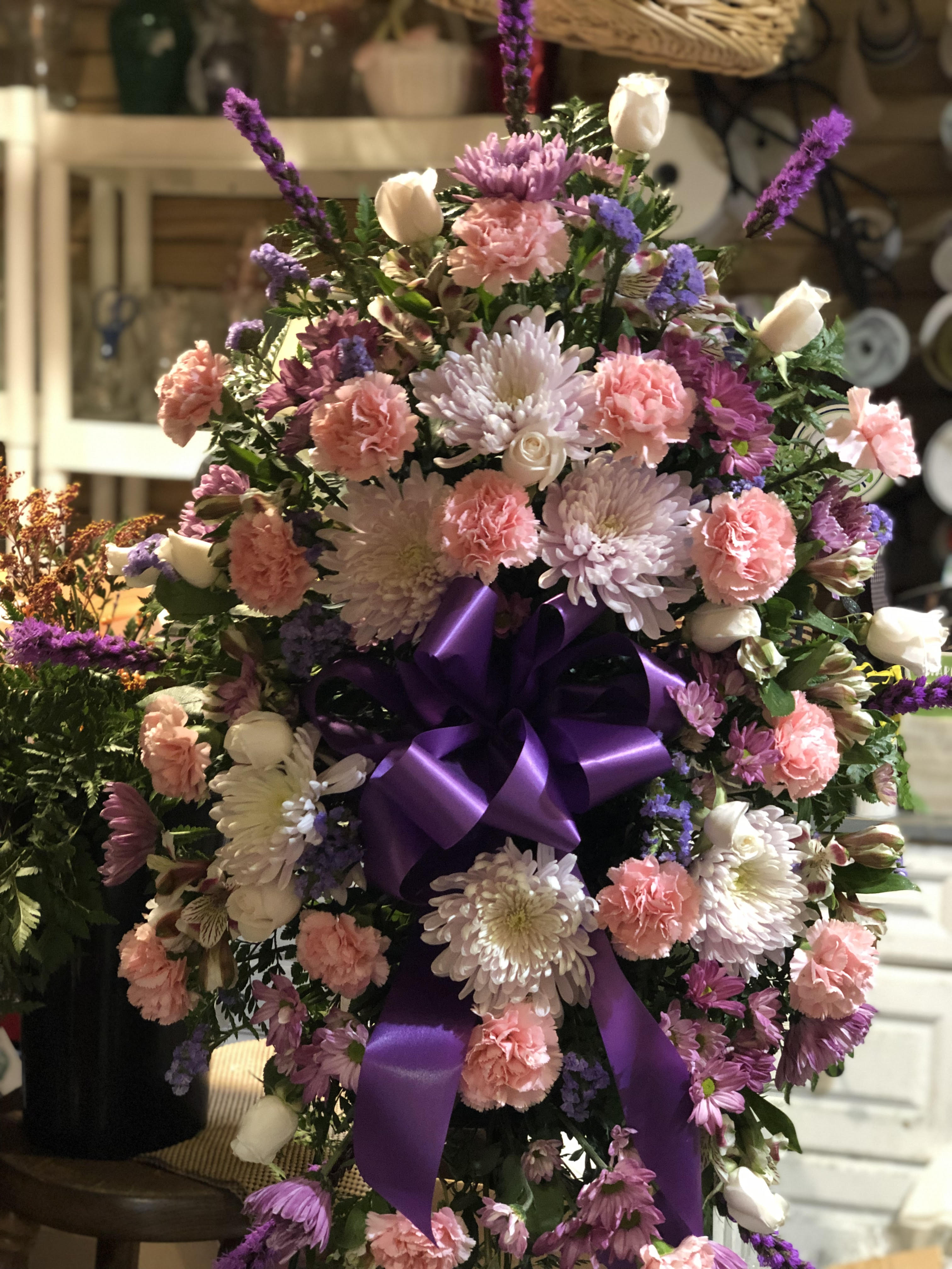 Large bouquet of pink and white flowers with a purple ribbon