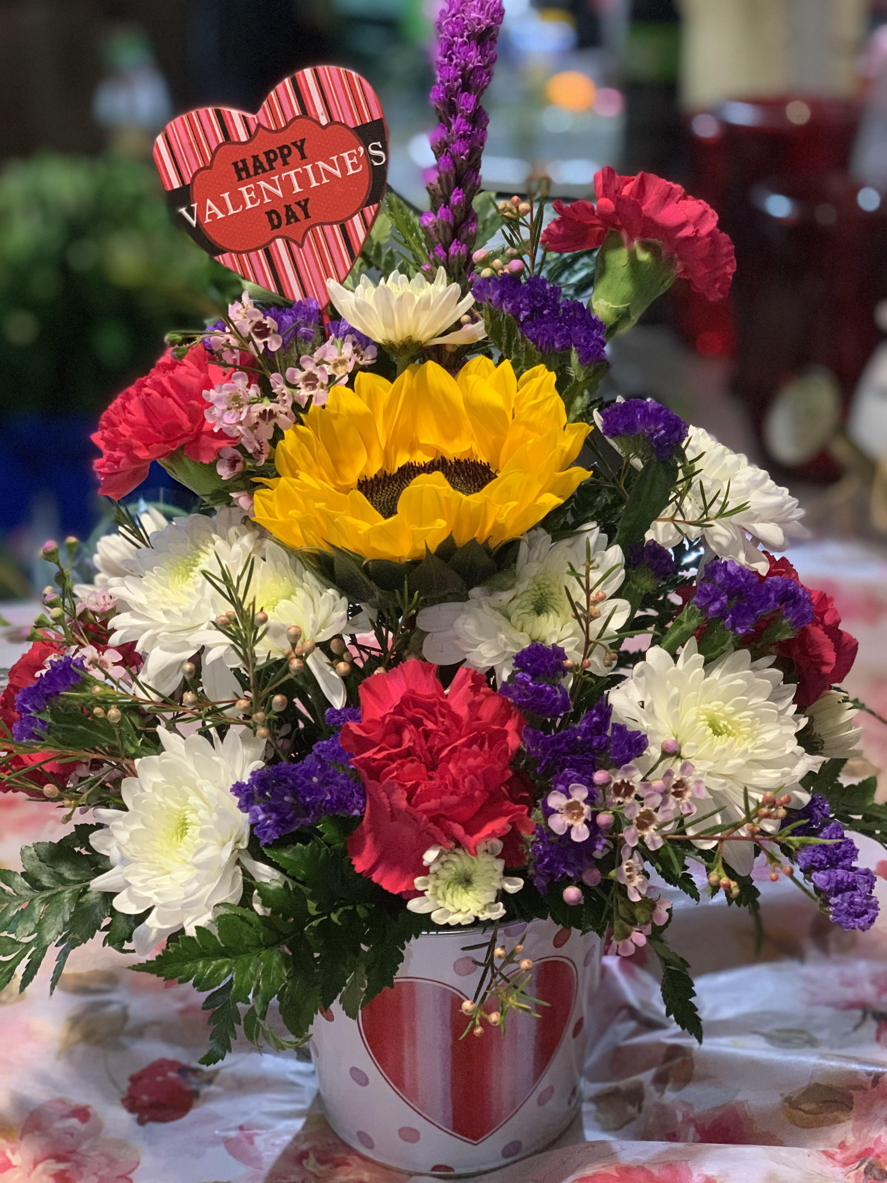 Mixed flower arrangement in a heart-decorated pot with a Valentine sign