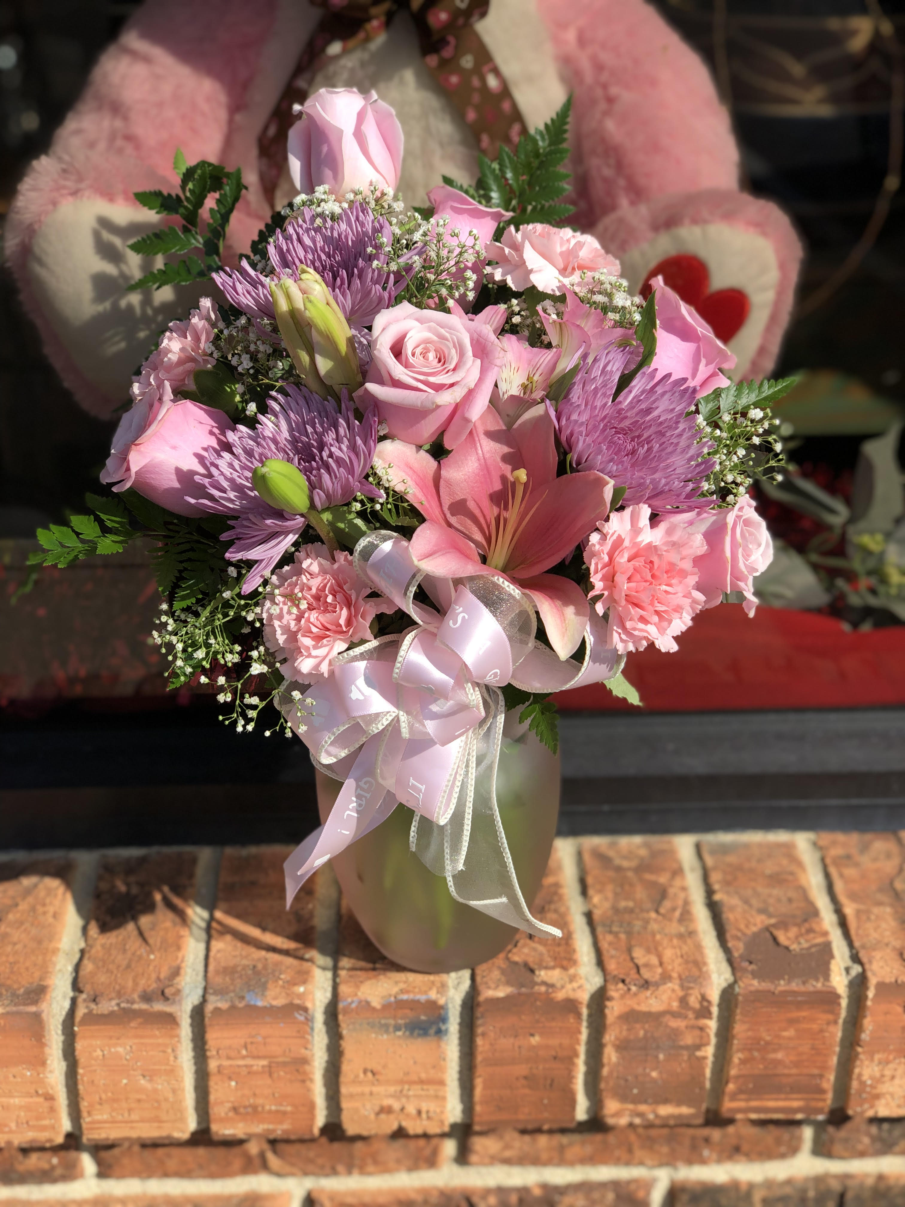 Pink mixed bouquet in a vase with a ribbon bow