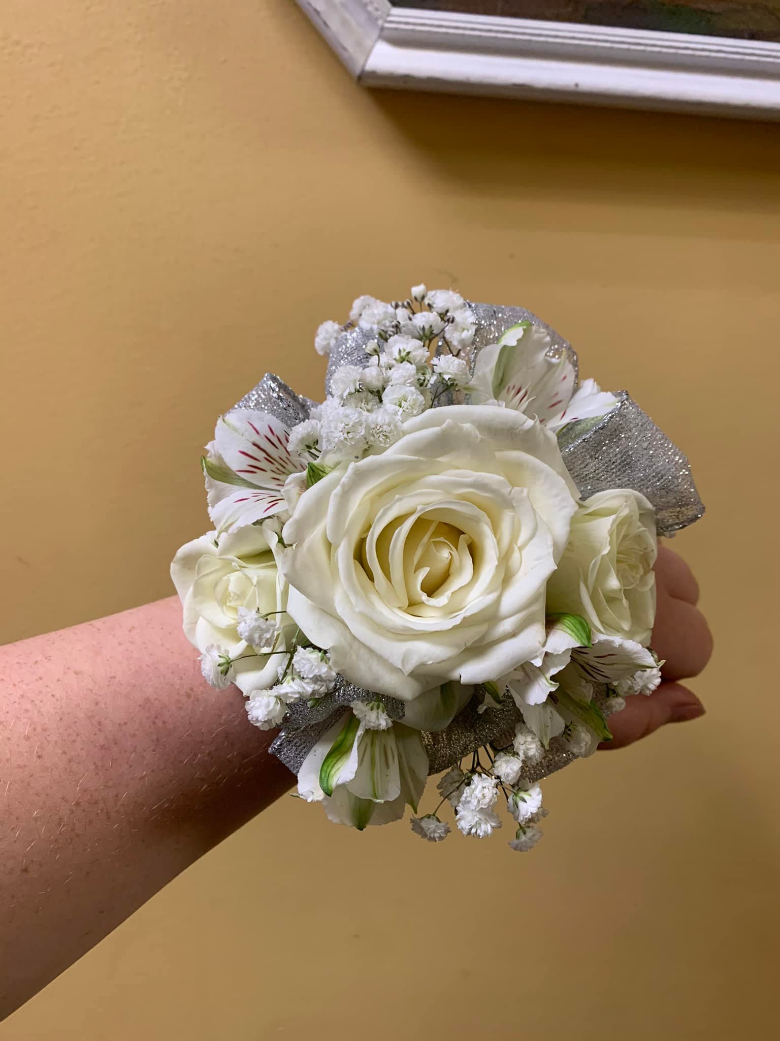 White rose wrist corsage with small white filler flowers and silver ribbon