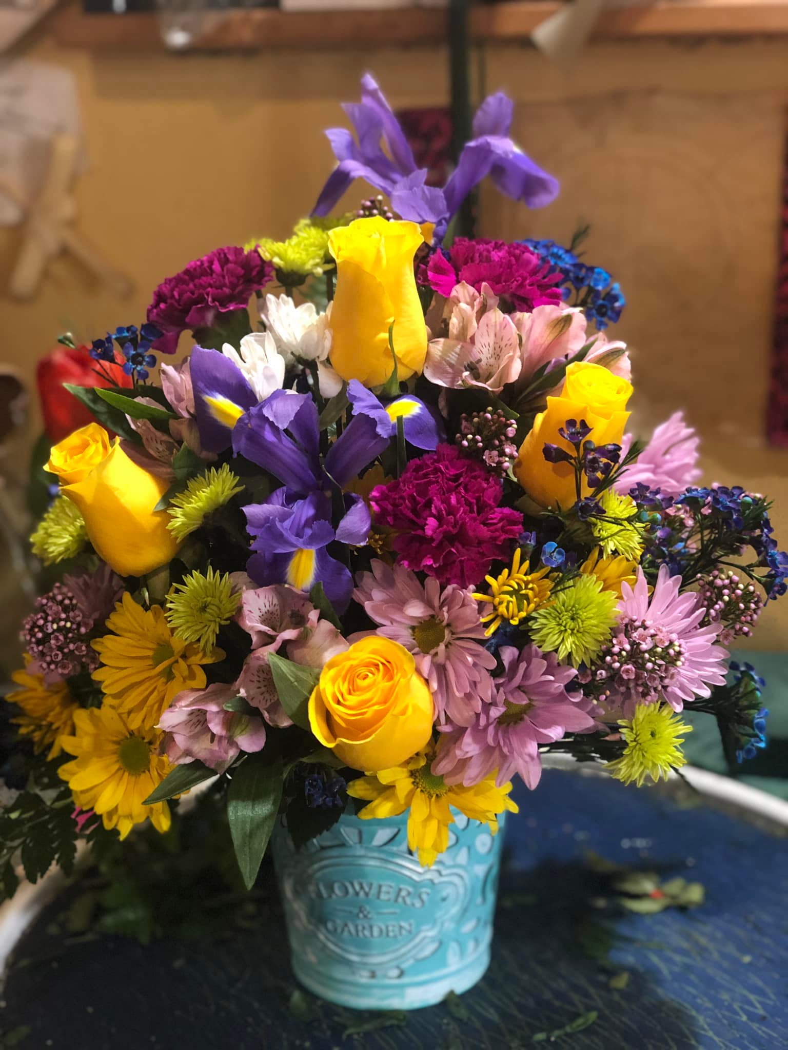 Colorful mixed bouquet in a turquoise tin container
