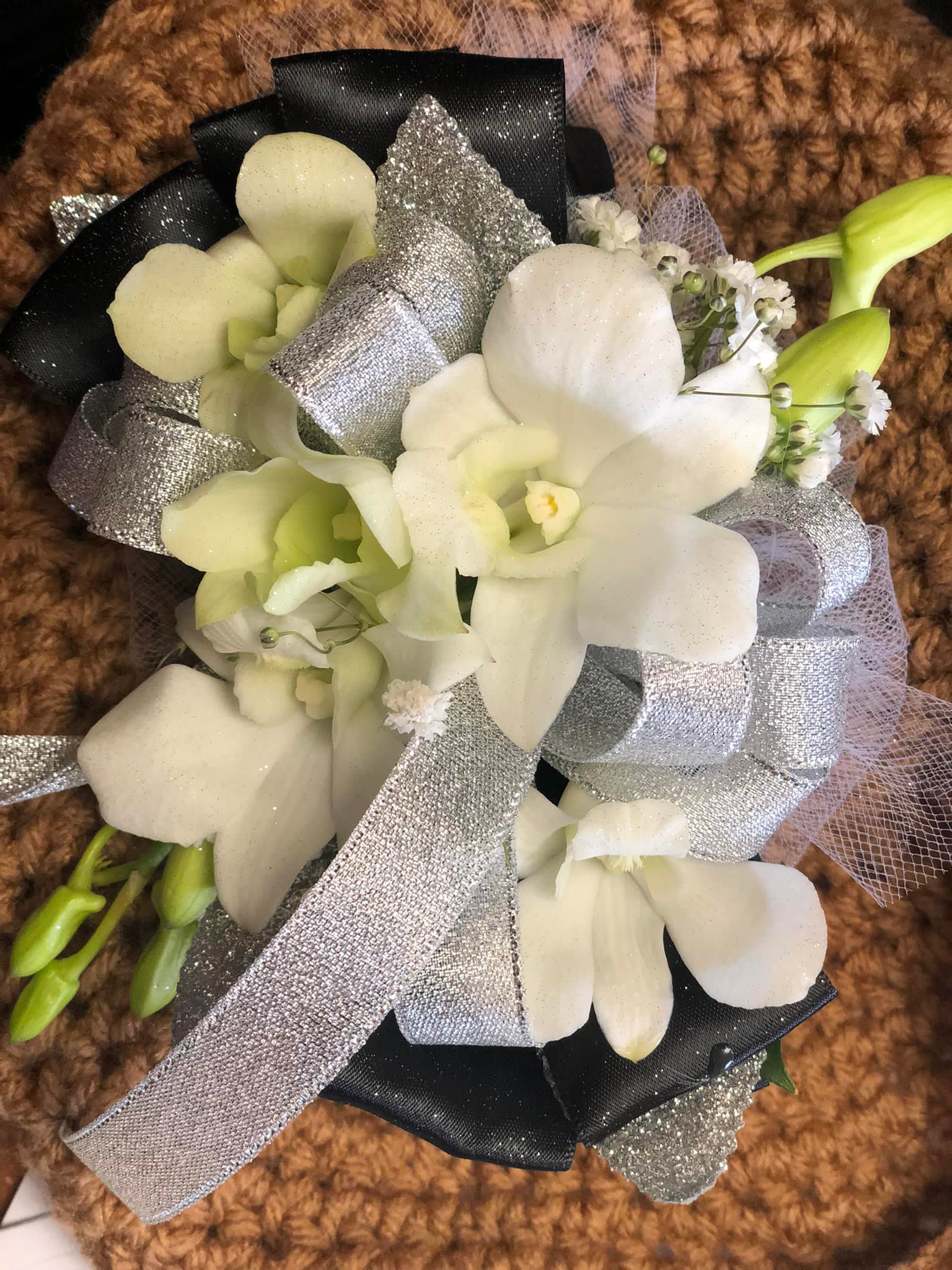 White orchid bouquet with silver ribbon and black wrap