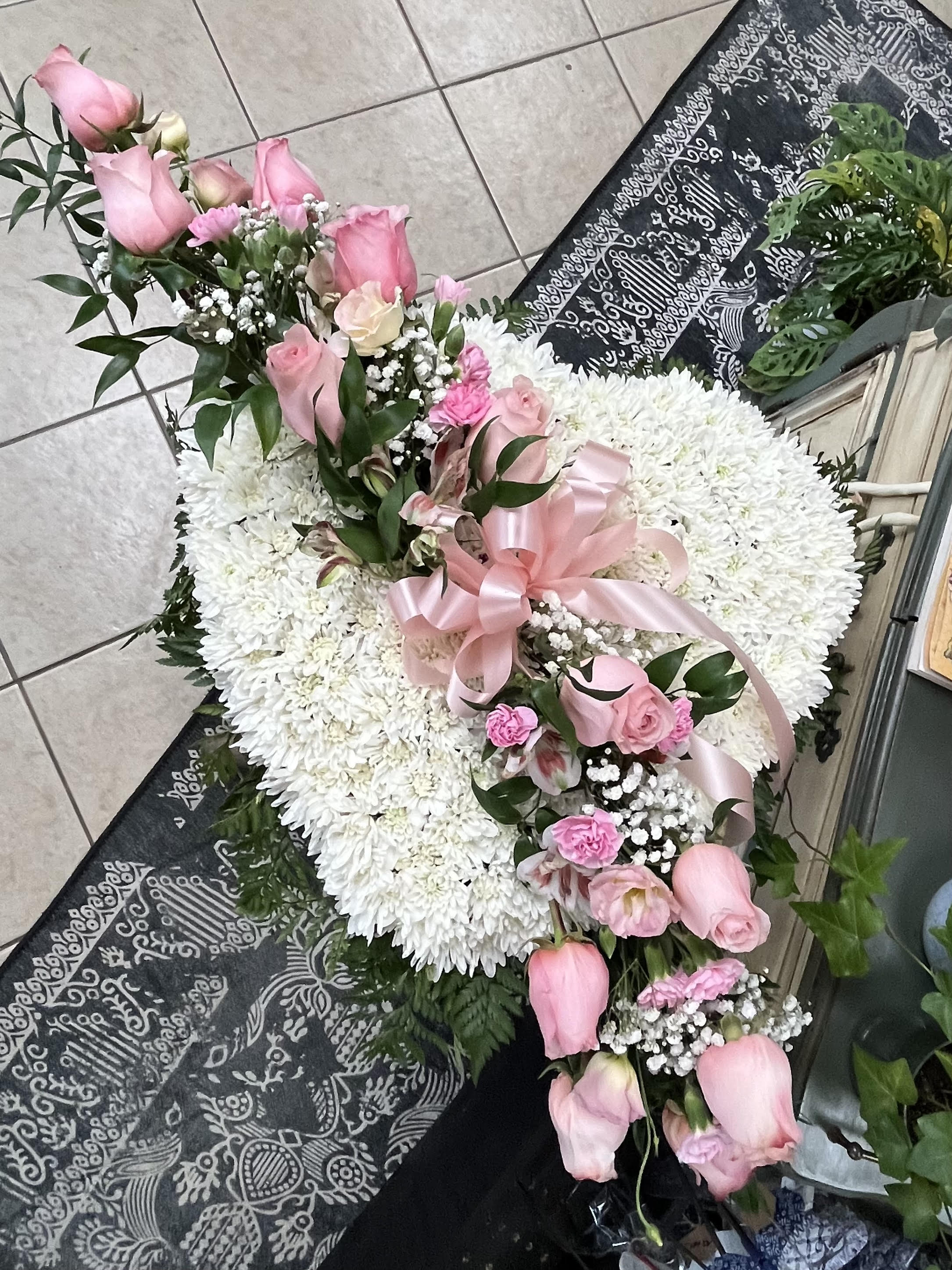 Heart-shaped white chrysanthemum wreath with pink roses and ribbon
