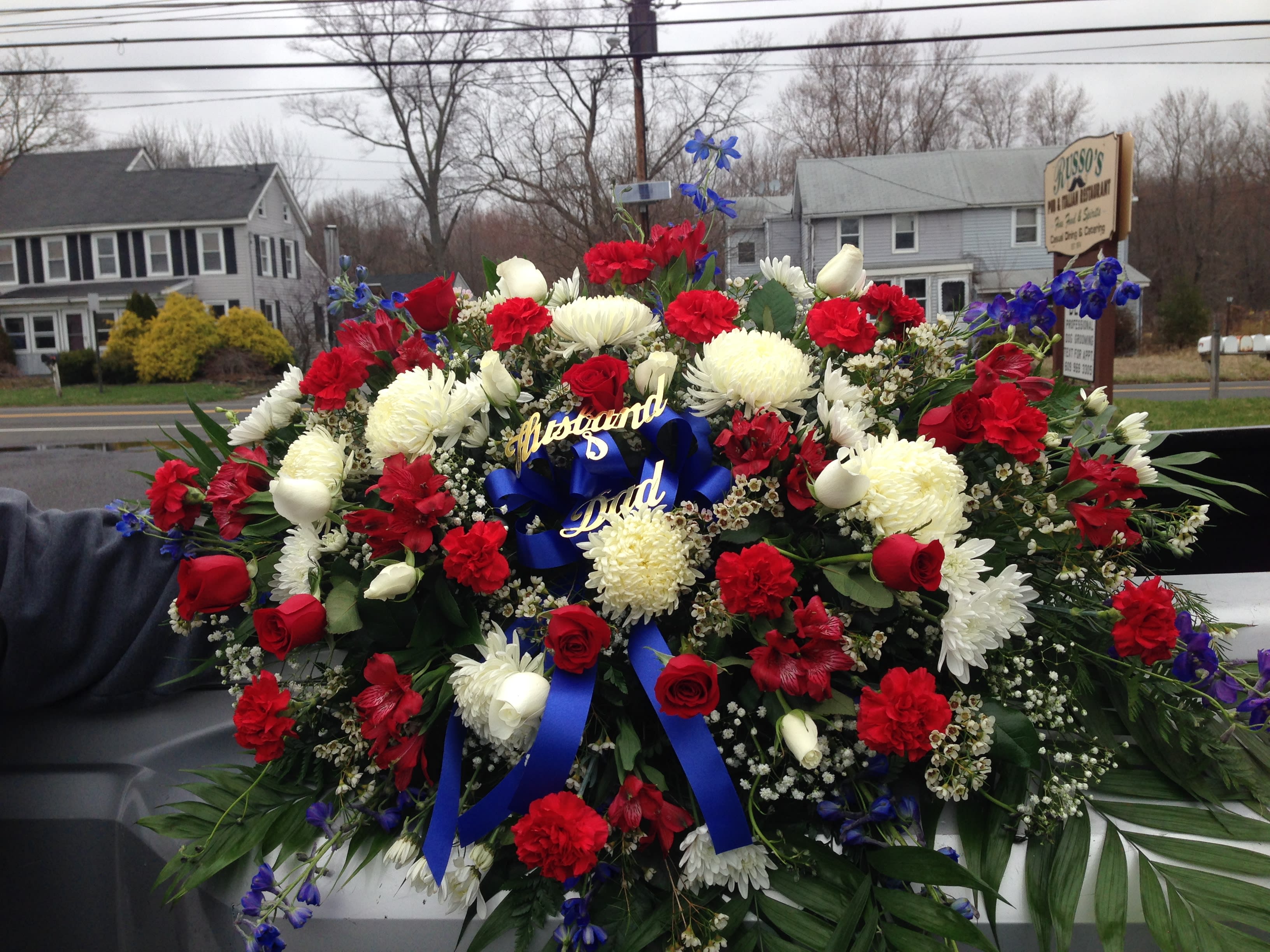 Large red, white, and blue funeral spray with ribbon tribute