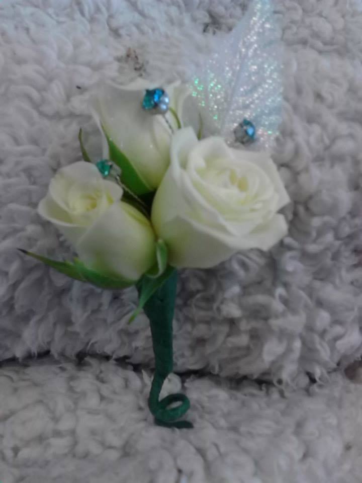 Small white rose corsage with green ribbon and blue accents