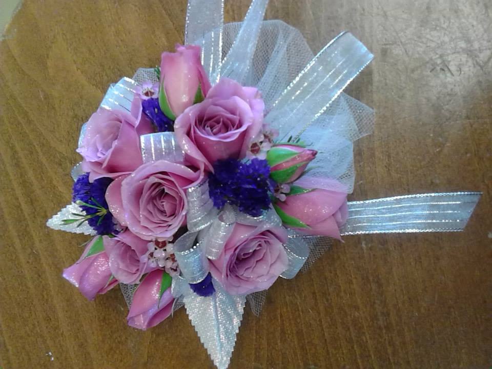 Small bouquet of pink roses with silver ribbon and purple accents