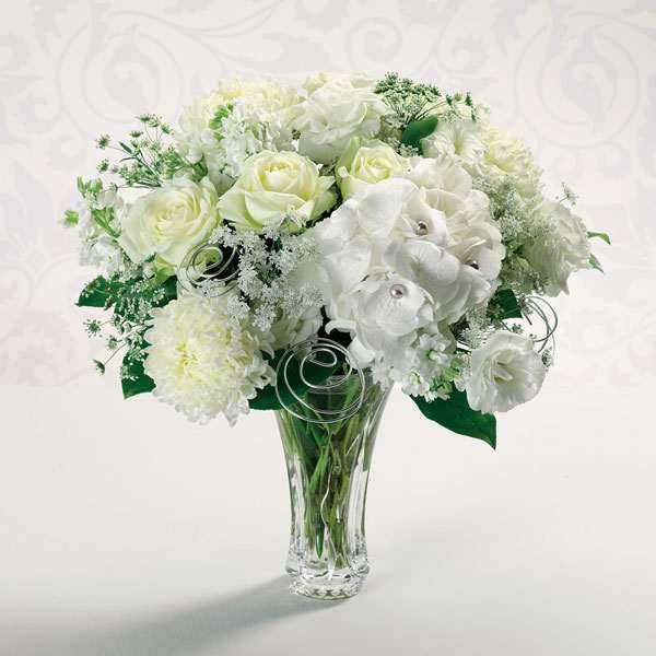Silver Anniversary - Pearl-studded hydrangea, white roses, Queen Anne's lace and football mums recall all your years together. Show her that "together" is still where you love to be.