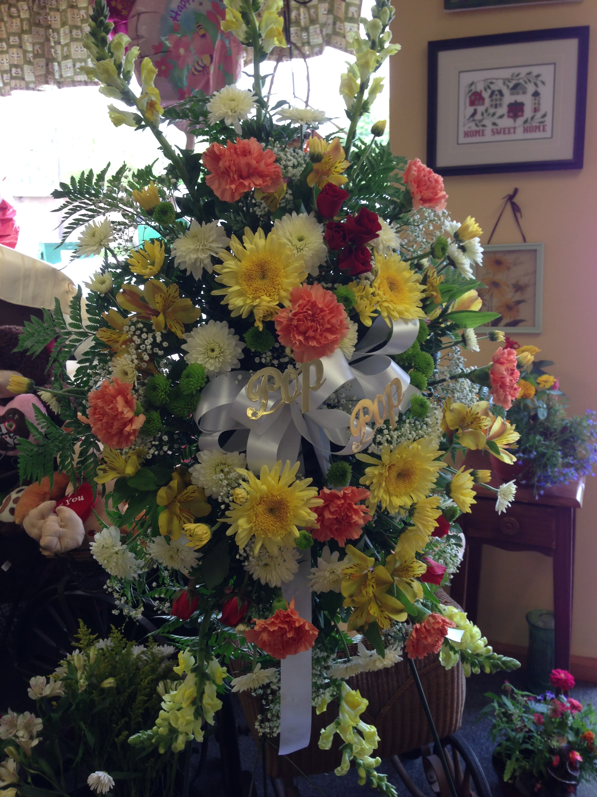Large standing floral spray with yellow, white, orange, and red blooms