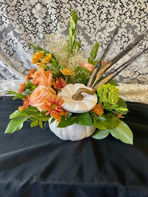 Pumpkin-shaped floral arrangement with peach roses and orange mums