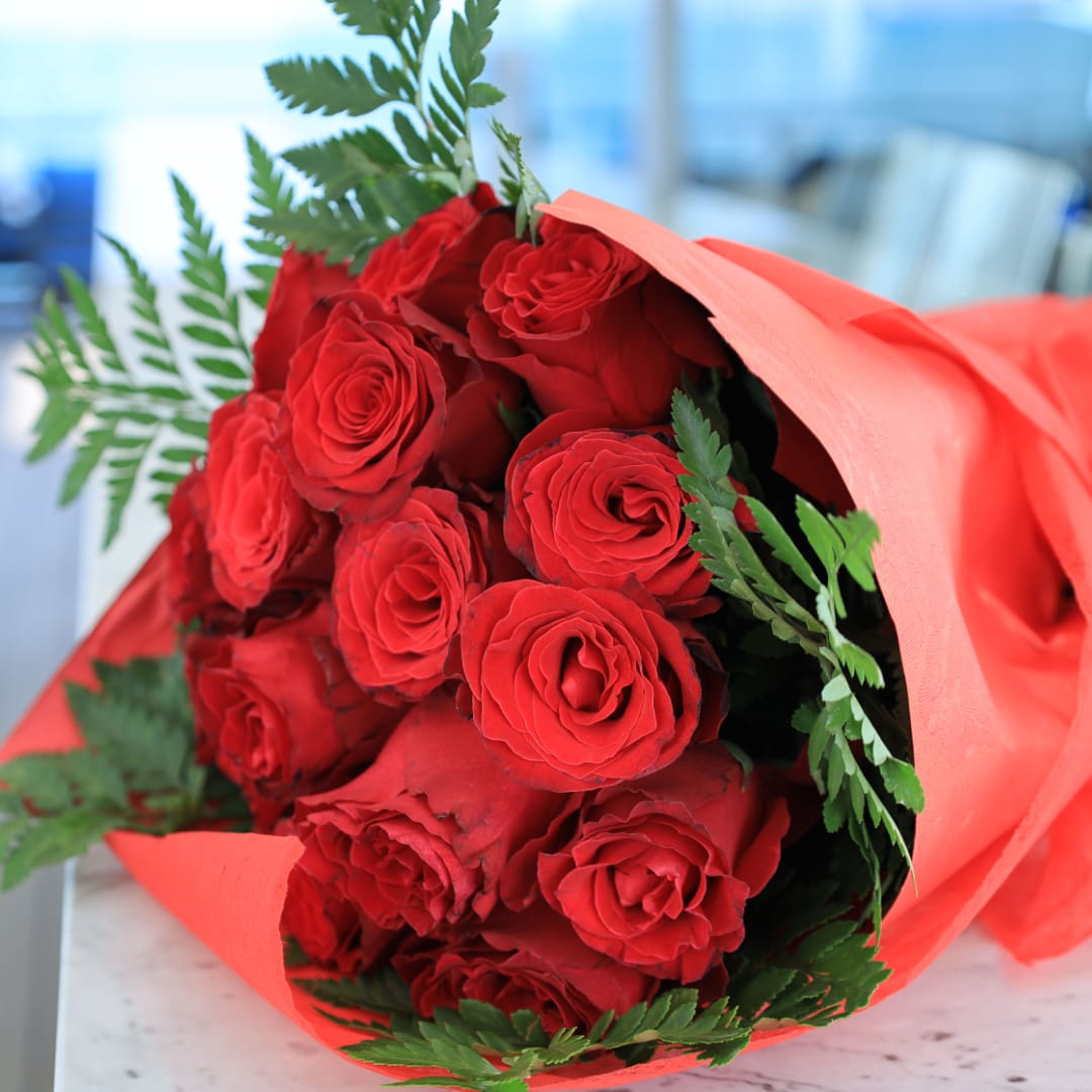 Bouquet of red roses wrapped in coral paper