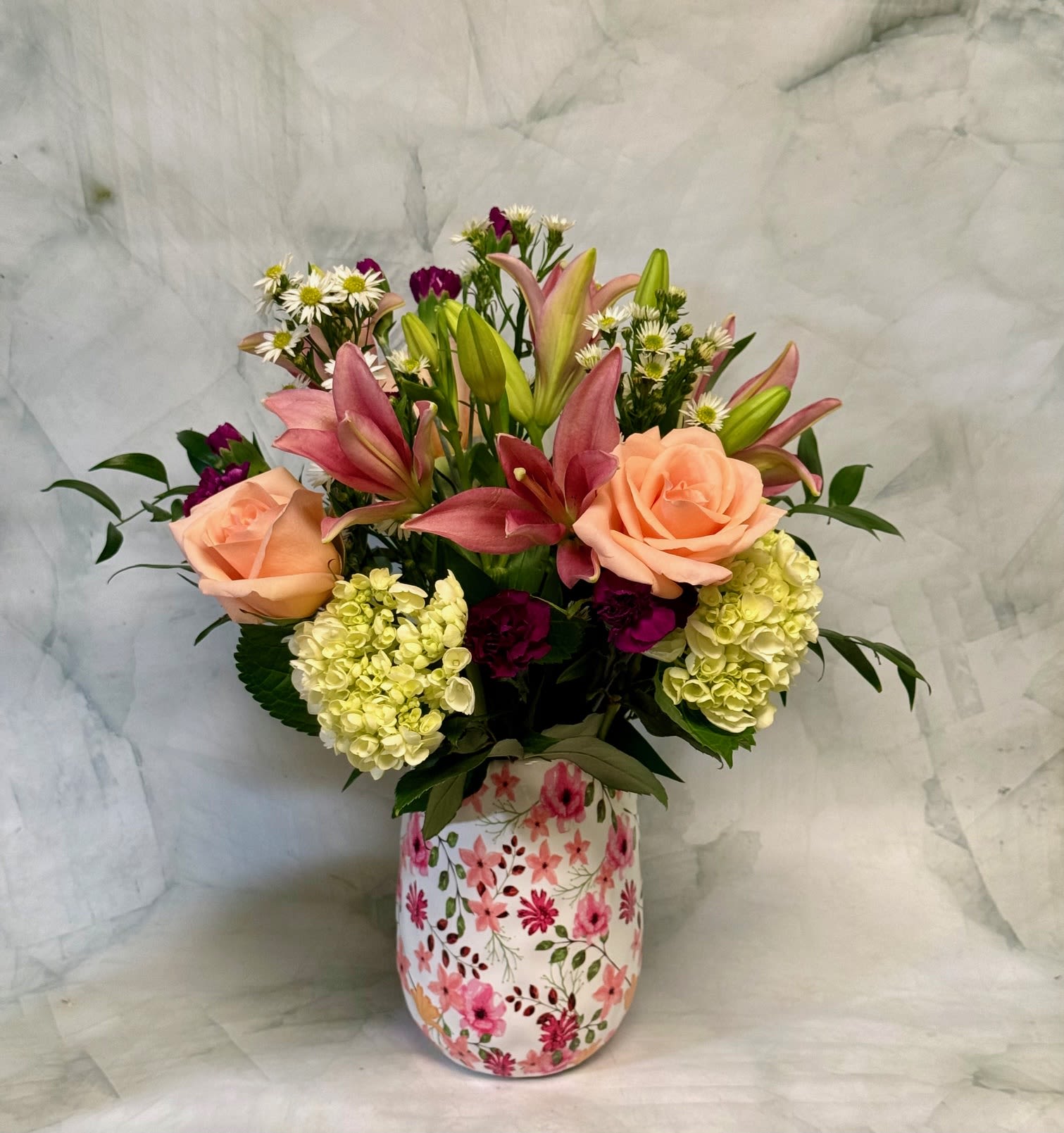 Spring Garden - Send Mom a beautiful garden-style flower arrangement from a trusted Philadelphia florist, designed to capture the natural charm of a blooming garden. This lush bouquet features a fresh mix of lilies, roses, hydrangeas, monte casino asters, mini carnations, and ruscus, creating a soft, elegant look she’ll love. Perfect for Mother’s Day, birthdays, or just because, this garden-inspired floral design is handcrafted with premium blooms and arranged for maximum freshness and beauty. Order today for reliable flower delivery in Philadelphia and surprise Mom with a bouquet that feels like it was picked straight from the garden.