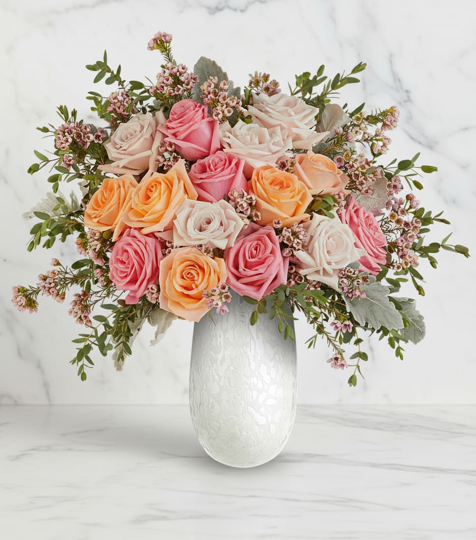 Bouquet of pink, peach, and white roses in a white vase