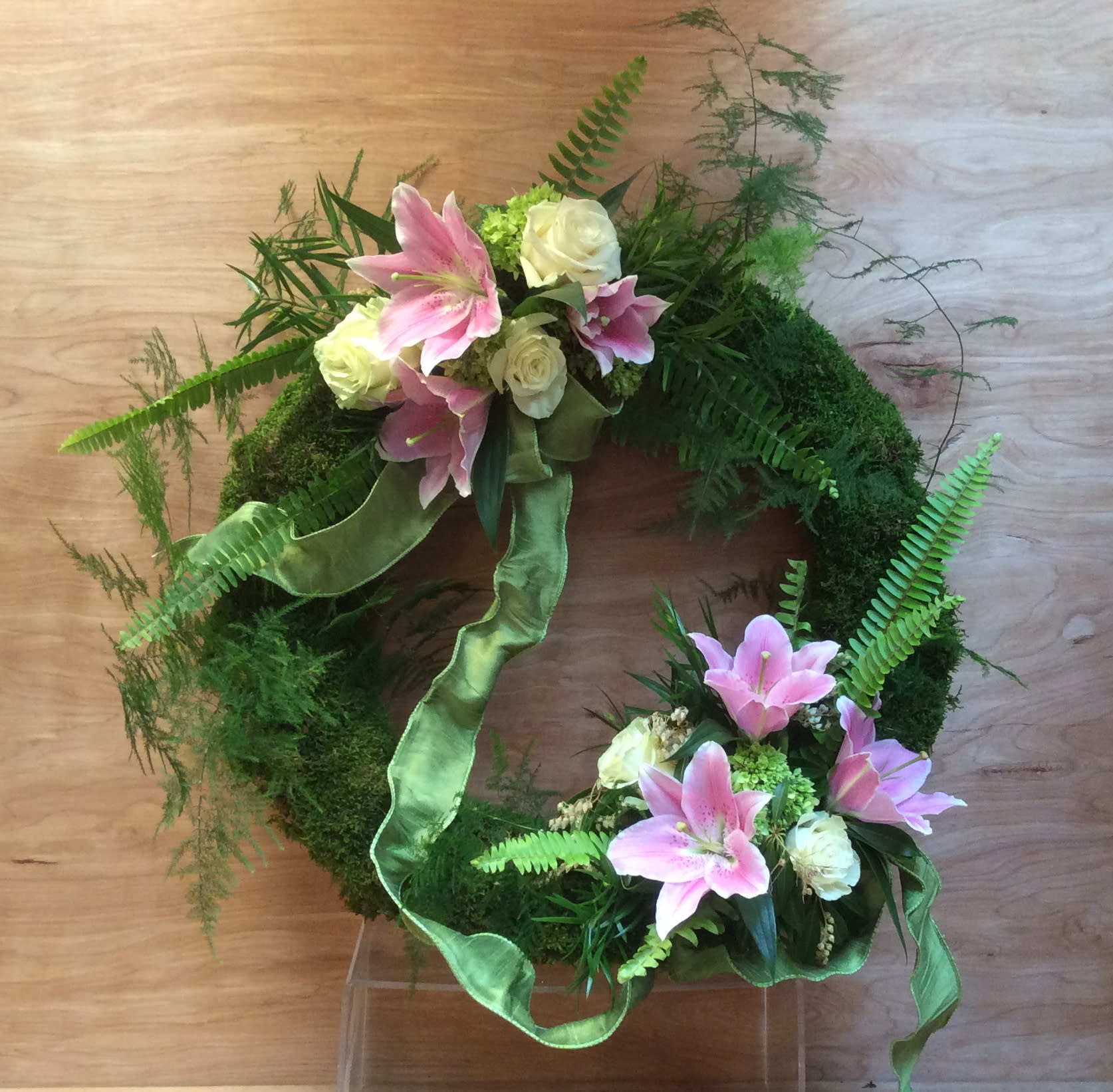 Green wreath with pink lilies and white roses