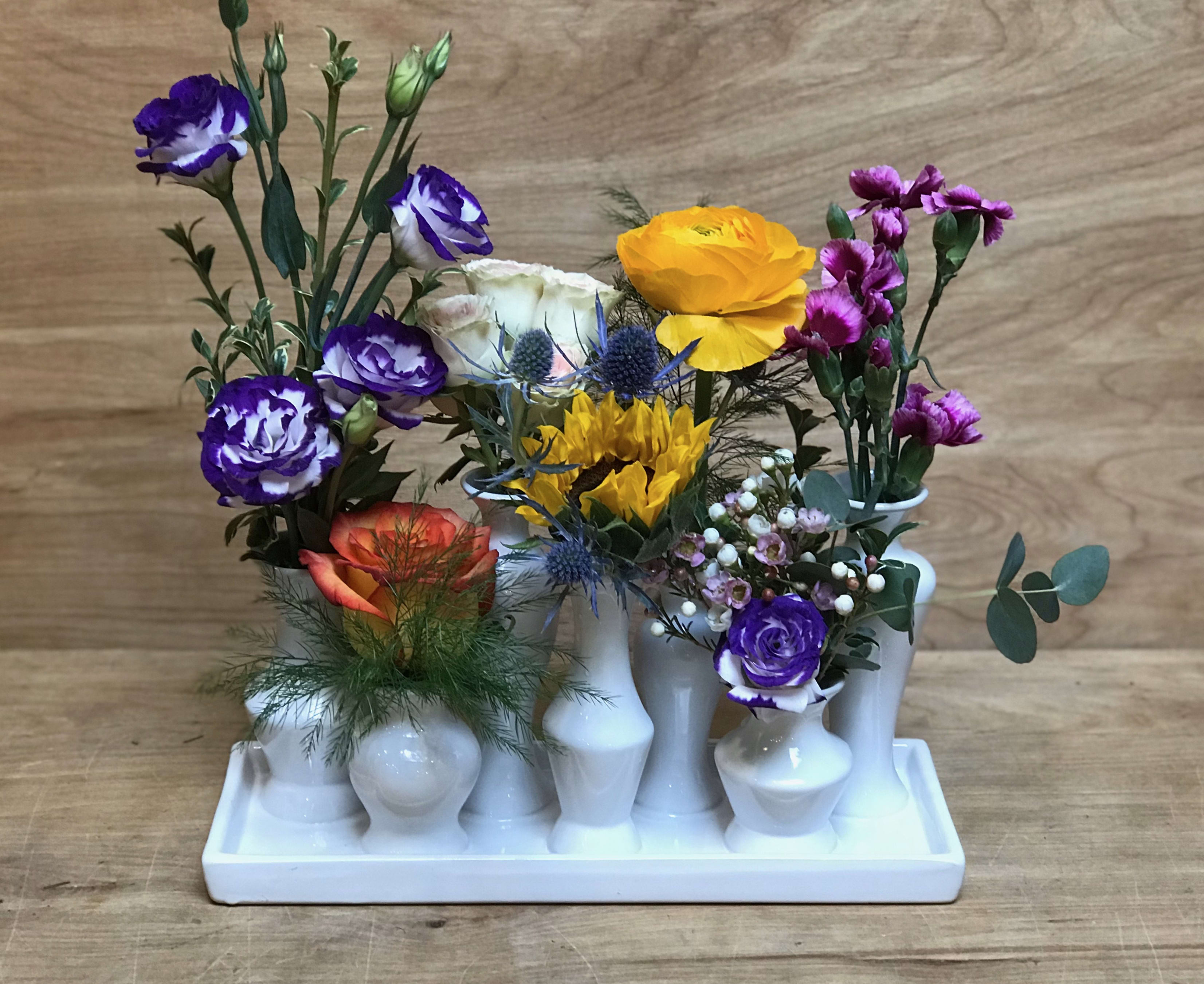 Mixed bouquet in white bud vases on a tray