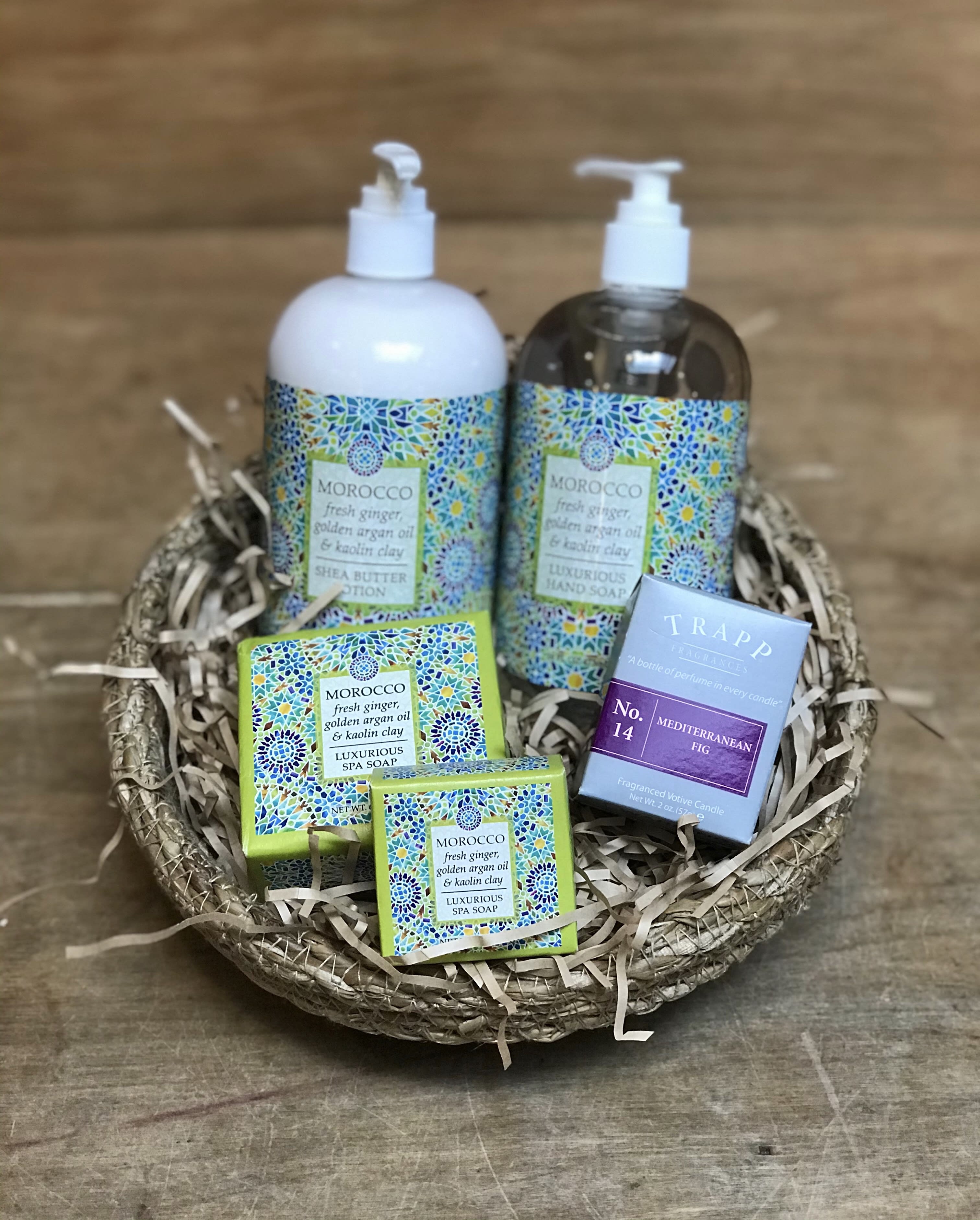 Spa gift basket with soap, lotion, and a candle in a woven tray
