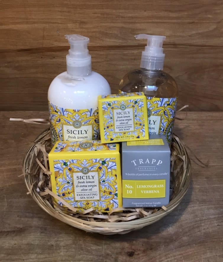 Gift basket with soap, lotion, and a candle in decorative boxes