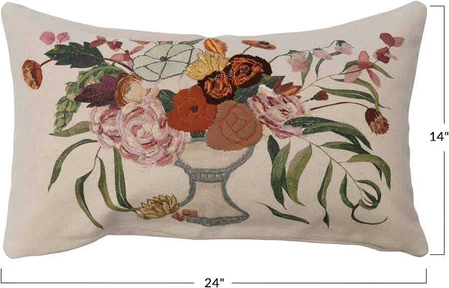 Floral embroidered pillow with a vase of mixed blooms