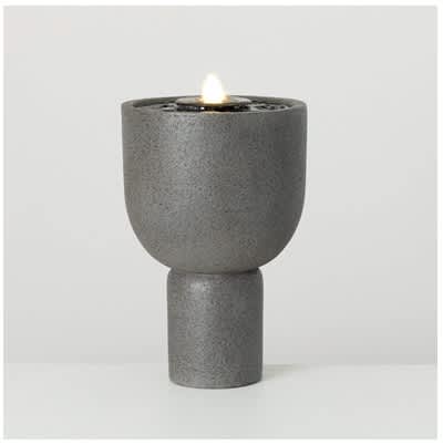 Gray pedestal candle holder with a lit candle