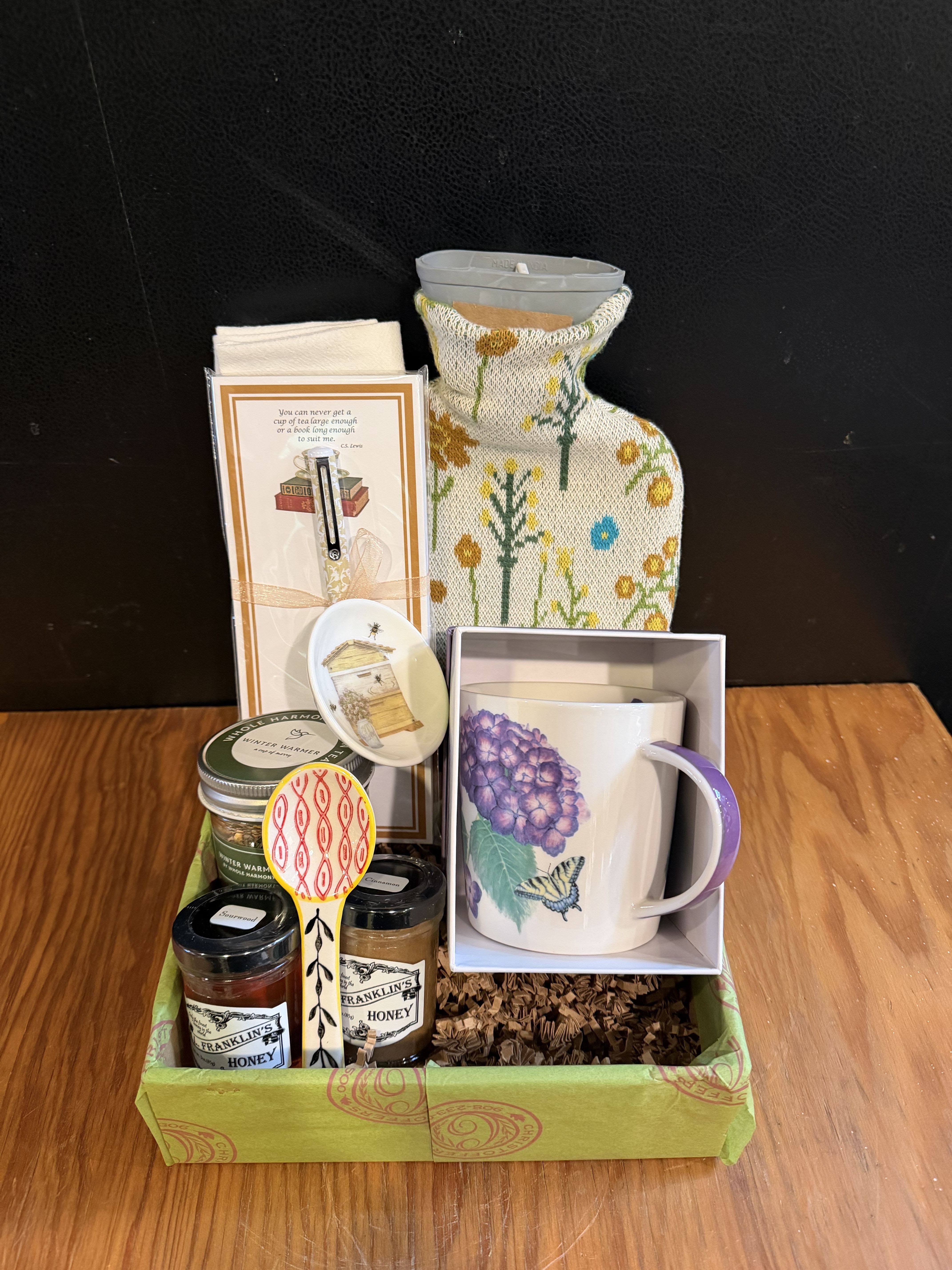 Gift basket with a mug, candles, honey jars, and small accessories