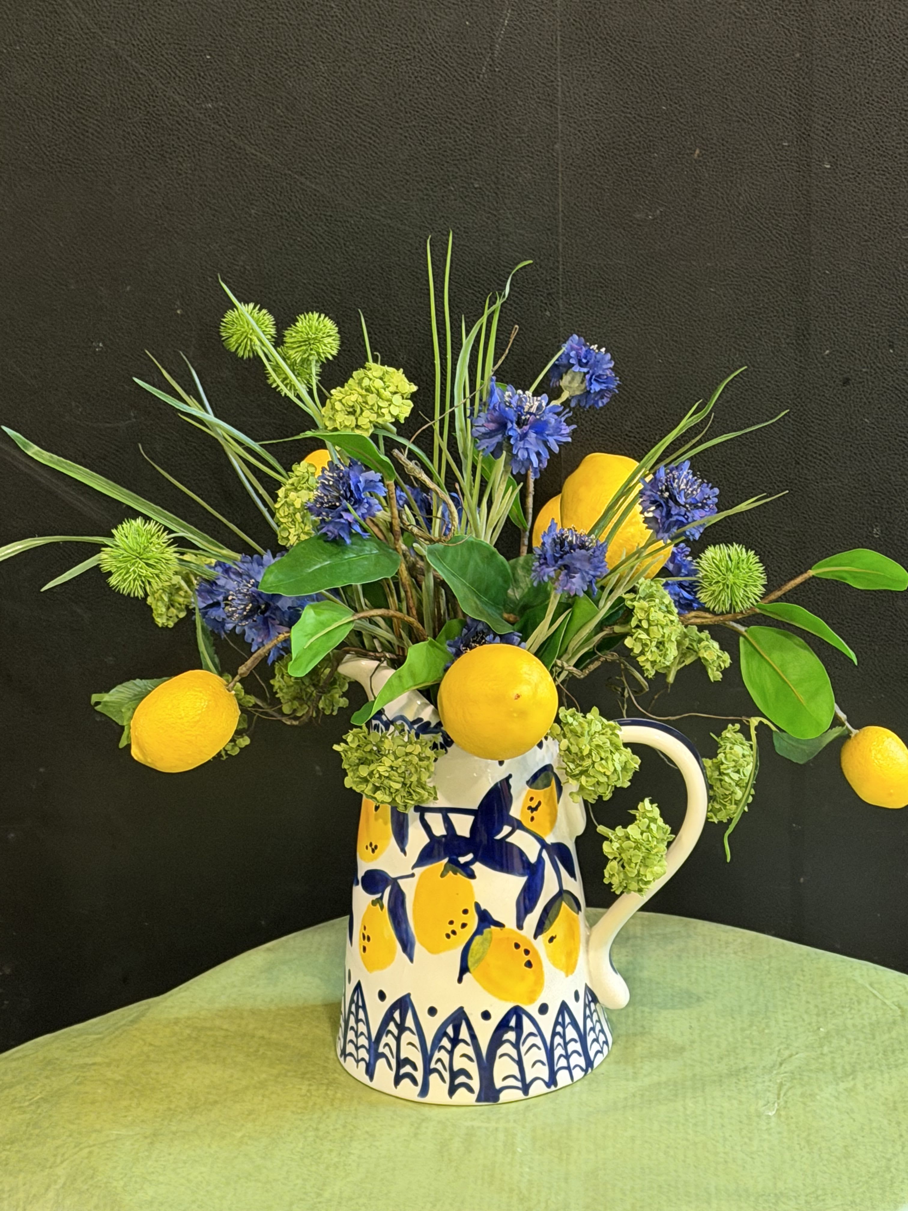 Citrus &amp; Blue - A Tuscan-inspired silk arrangement bursting with lemons, sapphire cornflowers, and green botanicals in a beautiful hand-painted pitcher. Timeless, vibrant, and maintenance-free.