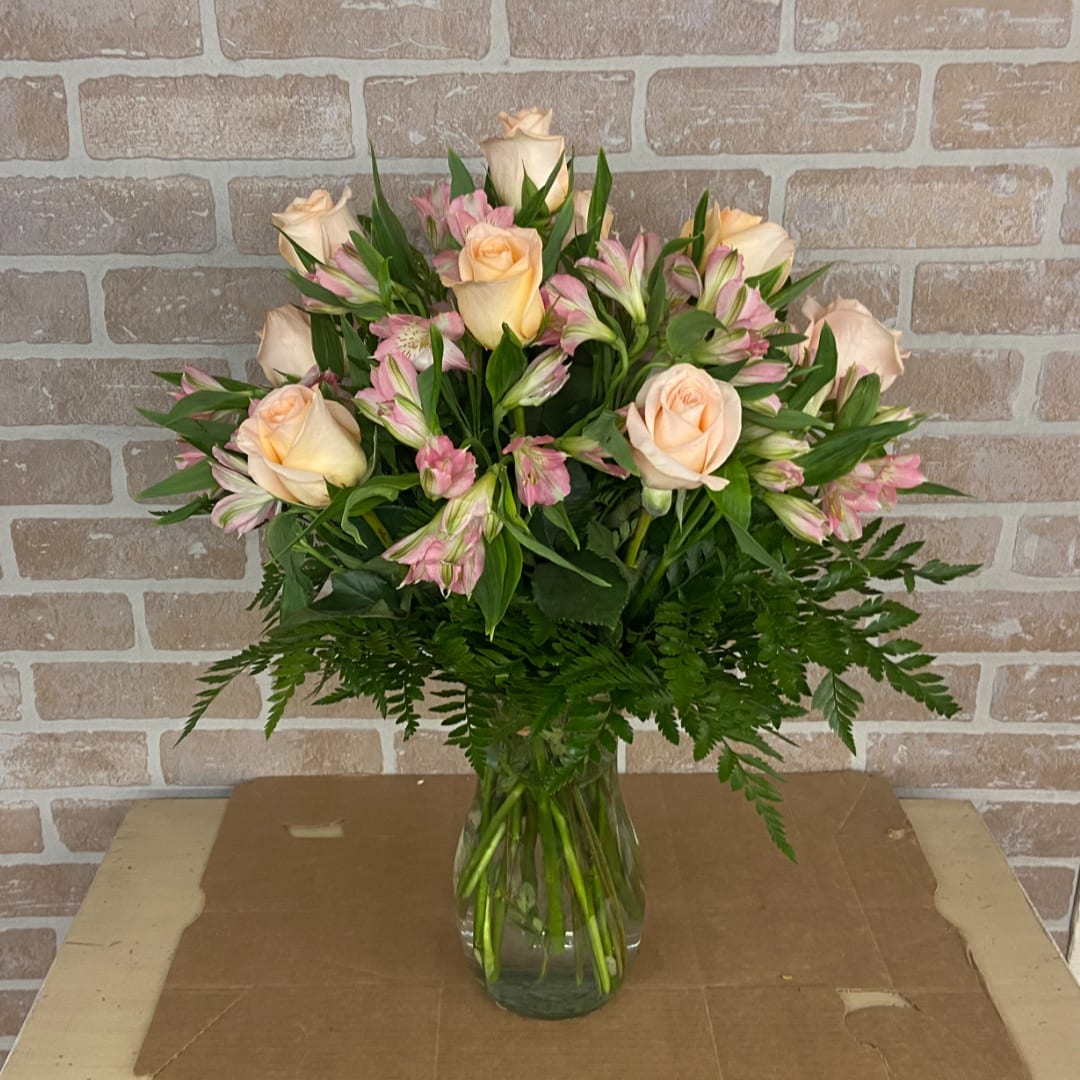 Peach roses and pink alstroemeria in a clear glass vase