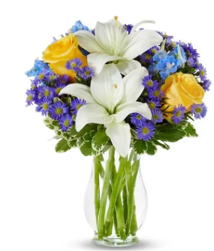 Blue Skies &amp; Sunshine - Two large white lilies open at the center of this rounded flower arrangement, creating an elegant focal point that instantly brightens any room. Blue Skies &amp; Sunshine is a cheerful everyday bouquet perfect for birthdays, thank-you gestures, spring celebrations, or simply to lift the spirits of the person you're thinking of-she'll feel genuinely celebrated by the crisp whites set against sunny yellow roses and cool blue and purple accents. 