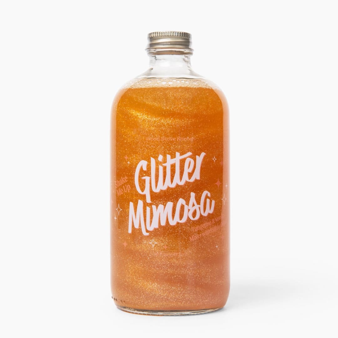 Bottle of orange glitter mimosa drink with a metal cap