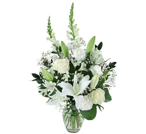 Condolence Arrangements  - All white flowers are expertly arranged in a clear glass vase. Our "Condolence" vase features lilies, alstroemerias, carnations, snapdragons and baby's breath.
