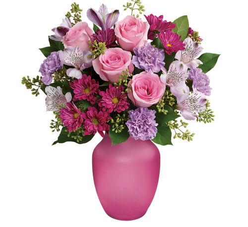 Spring Serenade arrangement - "Spring Serenade" whispers the melodies of the season with its enchanting composition. This arrangement orchestrates a symphony of pink roses, lavender alstroemeria, lavender carnations, and purple daisies