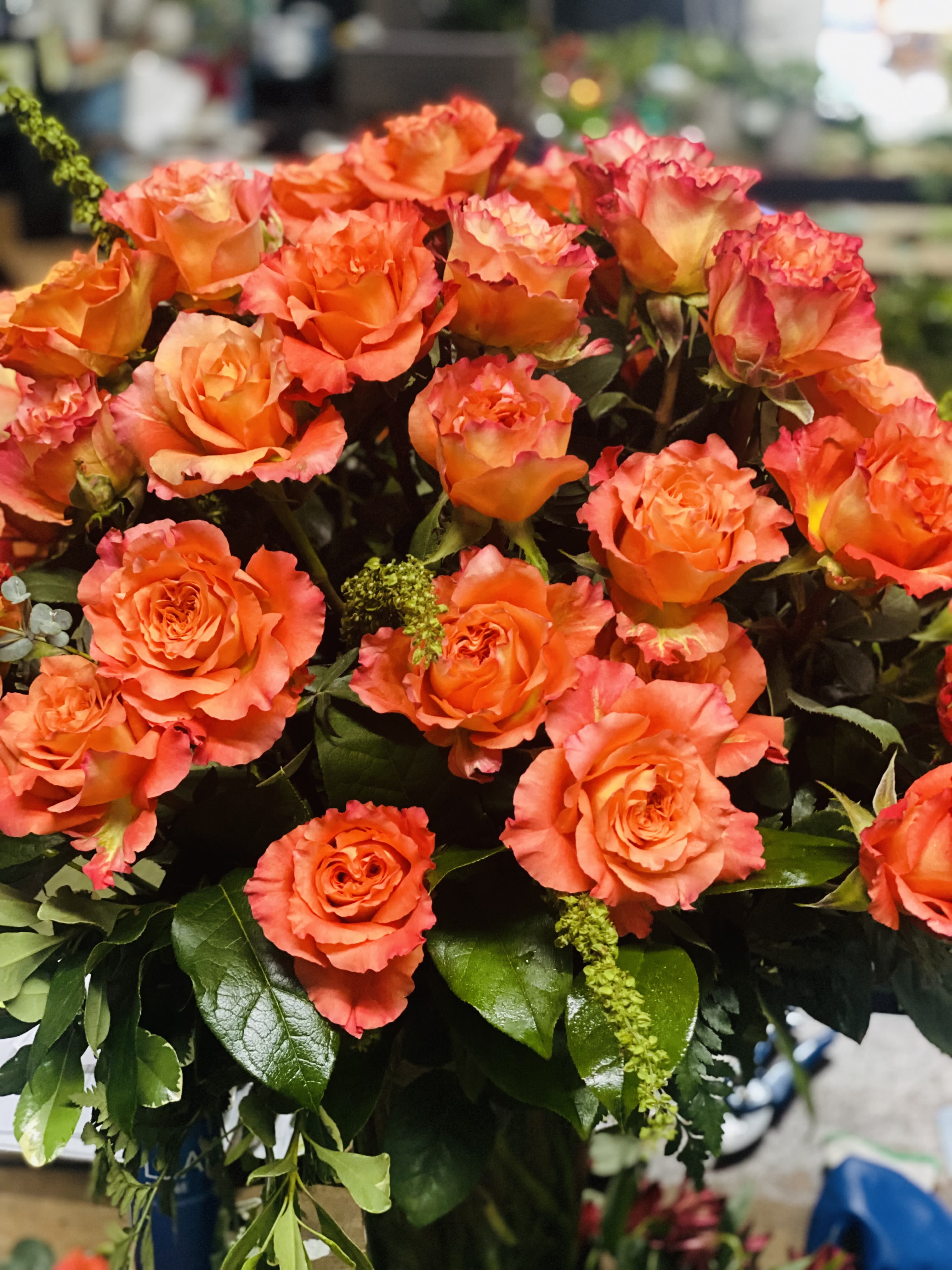 Free Spirit - Over 40 stems of free spirit roses designed tall in a glass vase with fresh greenery