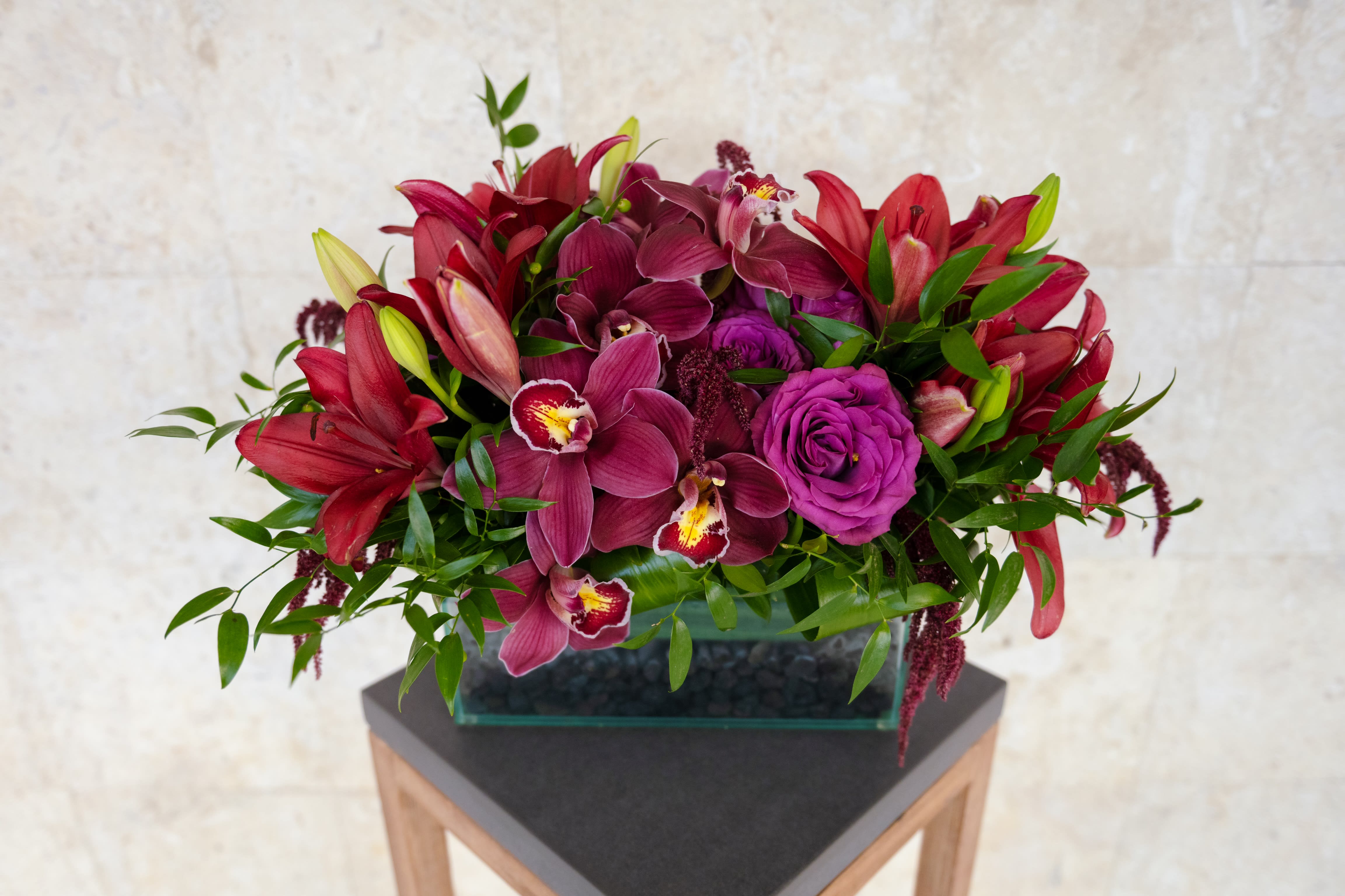 Magenta and red floral arrangement in a rectangular glass vase
