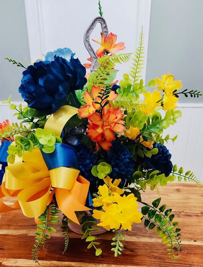 Colorful floral arrangement with blue, yellow, and orange blooms in a vase