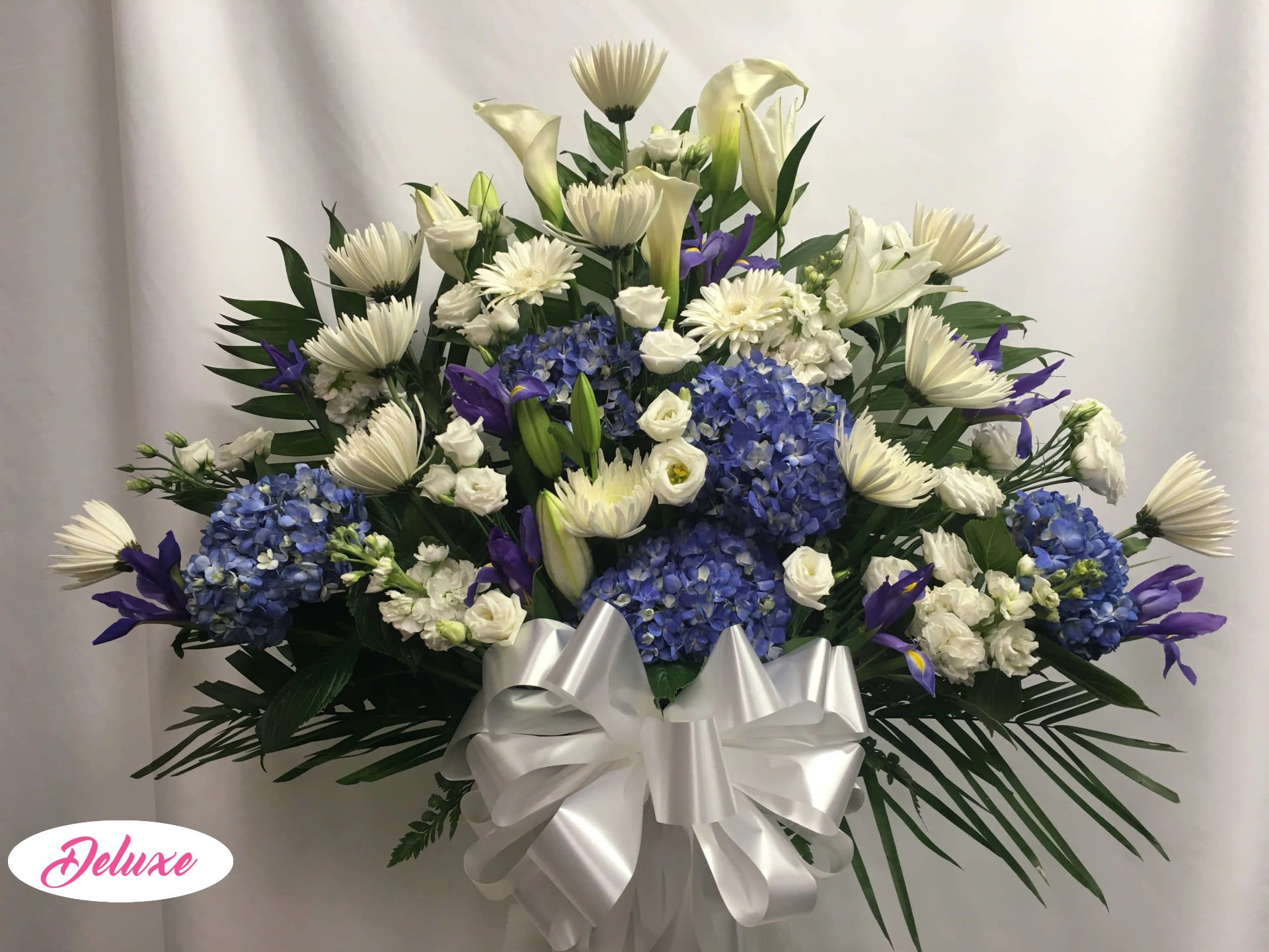 White and blue floral arrangement with a large silver bow
