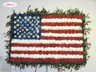 Floral arrangement shaped like the U.S. flag with red, white, and blue flowers