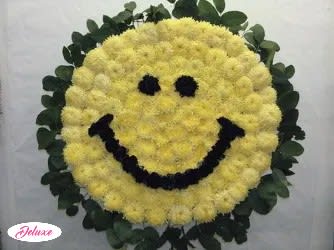 Yellow smiley-face floral wreath with dark eyes and mouth
