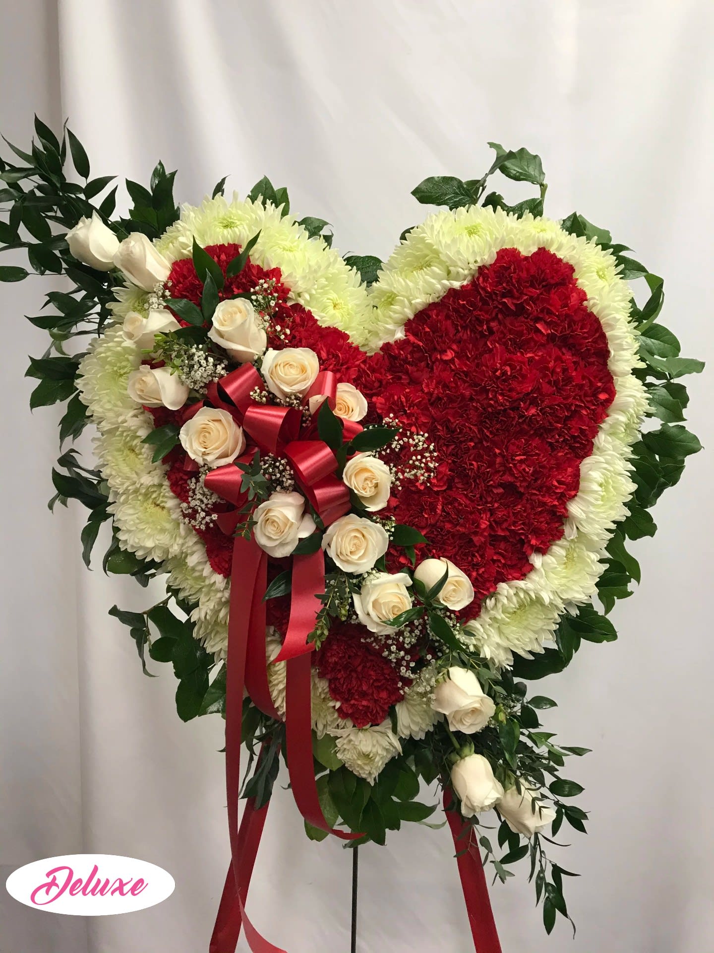 Heart-shaped floral spray with red and white flowers and cream roses