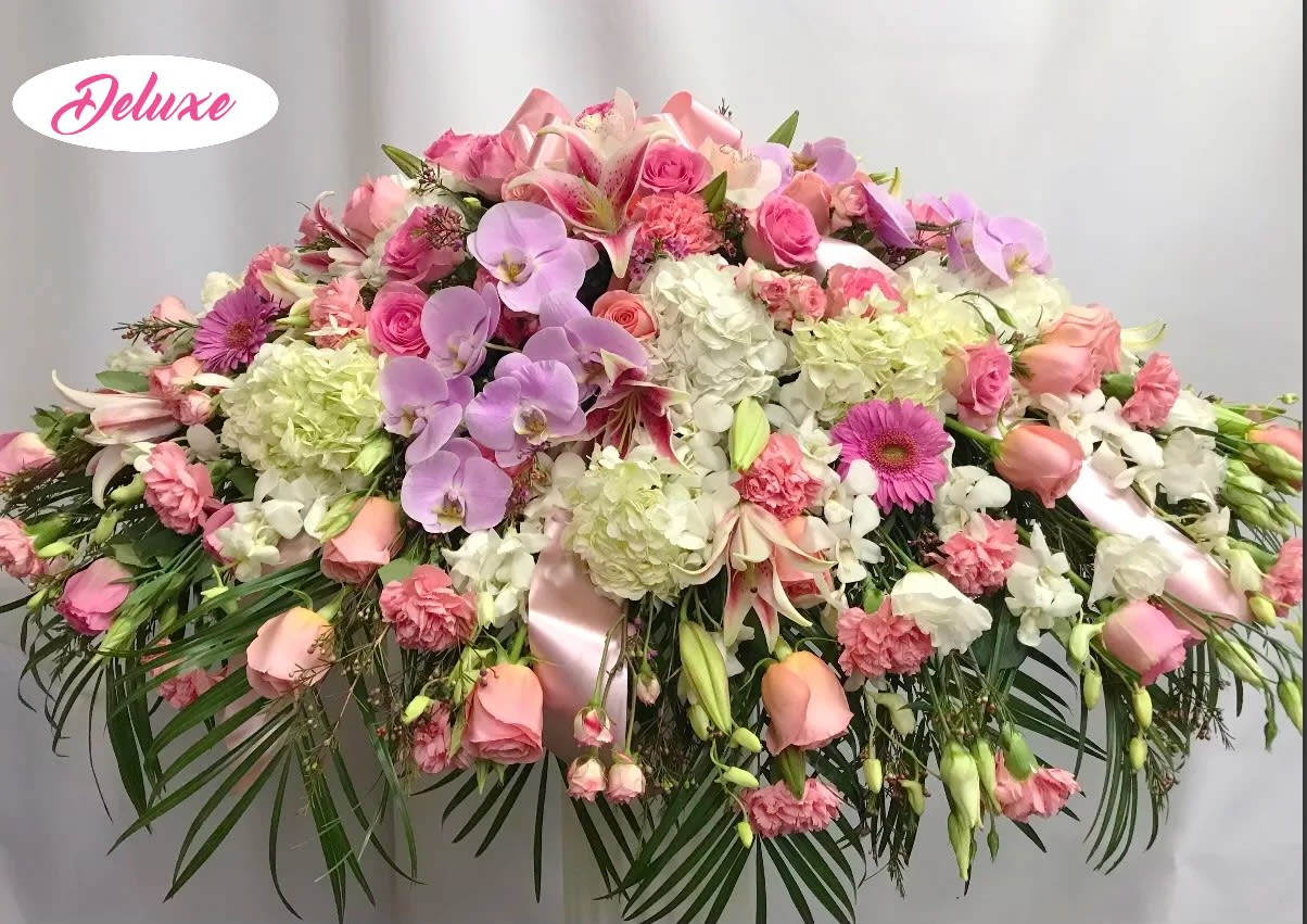 Forever in our Memories  - Forever in Our Memories is a graceful casket cover created to honor a cherished life with love, beauty, and heartfelt remembrance. This elegant floral tribute features a soft and romantic palette of lavender phalaenopsis orchids, white hydrangea, pink roses, pink carnations, and pink lilies, thoughtfully arranged to create a meaningful expression of sympathy and devotion. The delicate blend of lavender, white, and pink blooms symbolizes love, admiration, and treasured memories that will forever remain close to the heart. Handcrafted by our compassionate florists, Forever in Our Memories is a beautiful way to celebrate a life well lived and offer comfort to family and friends during a time of loss.