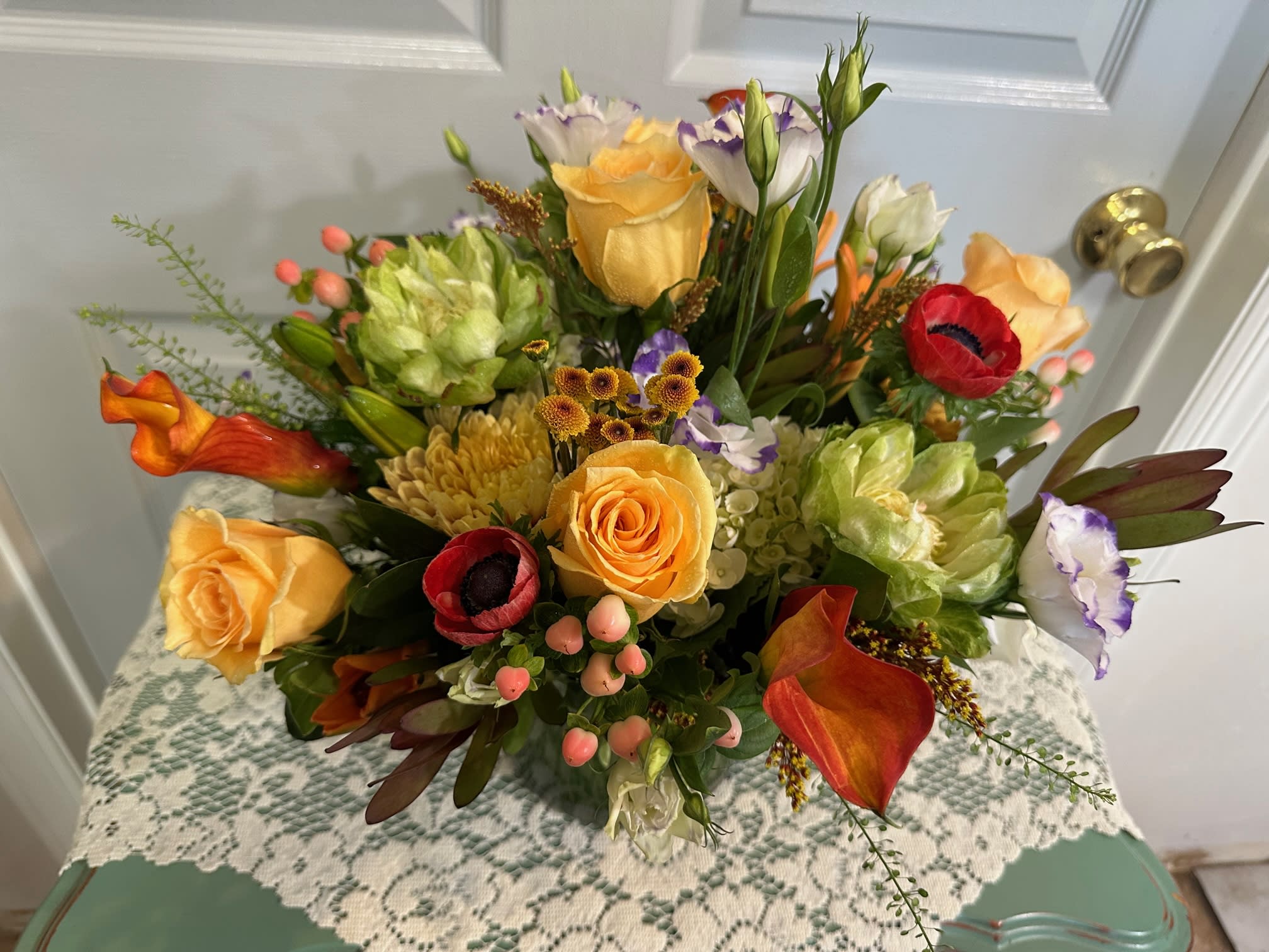 Mixed bouquet with yellow roses, red anemones, and orange calla lilies