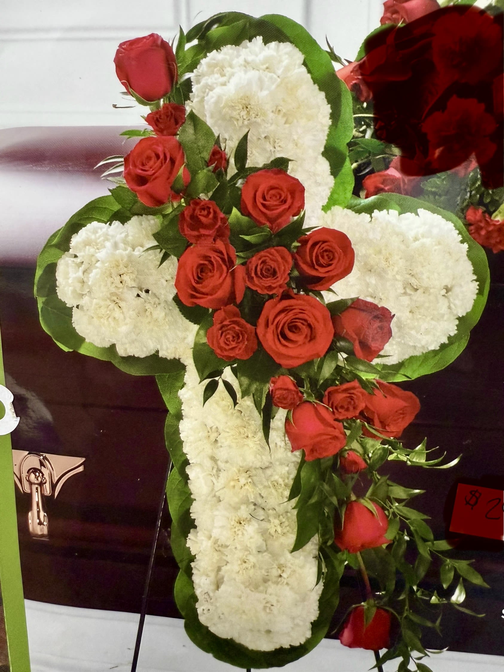 Cross-shaped floral arrangement with red roses and white carnations
