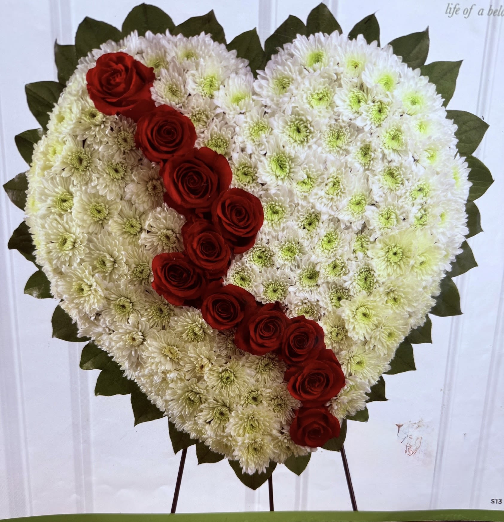Heart-shaped floral tribute with white chrysanthemums and red roses