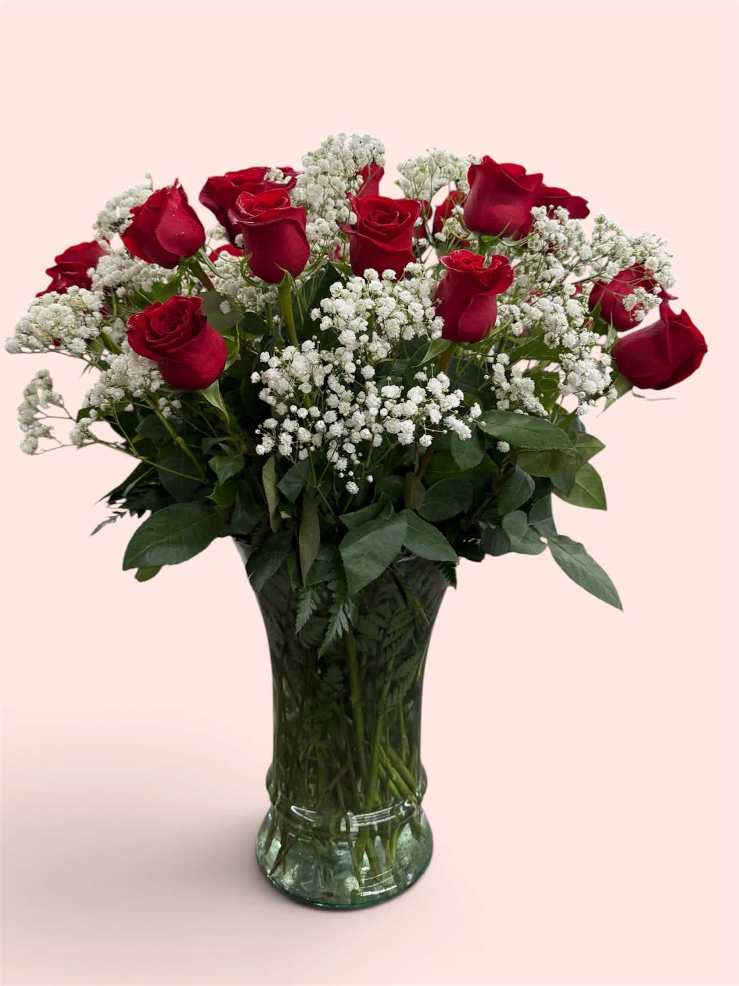 Red roses and white baby's breath in a clear glass vase
