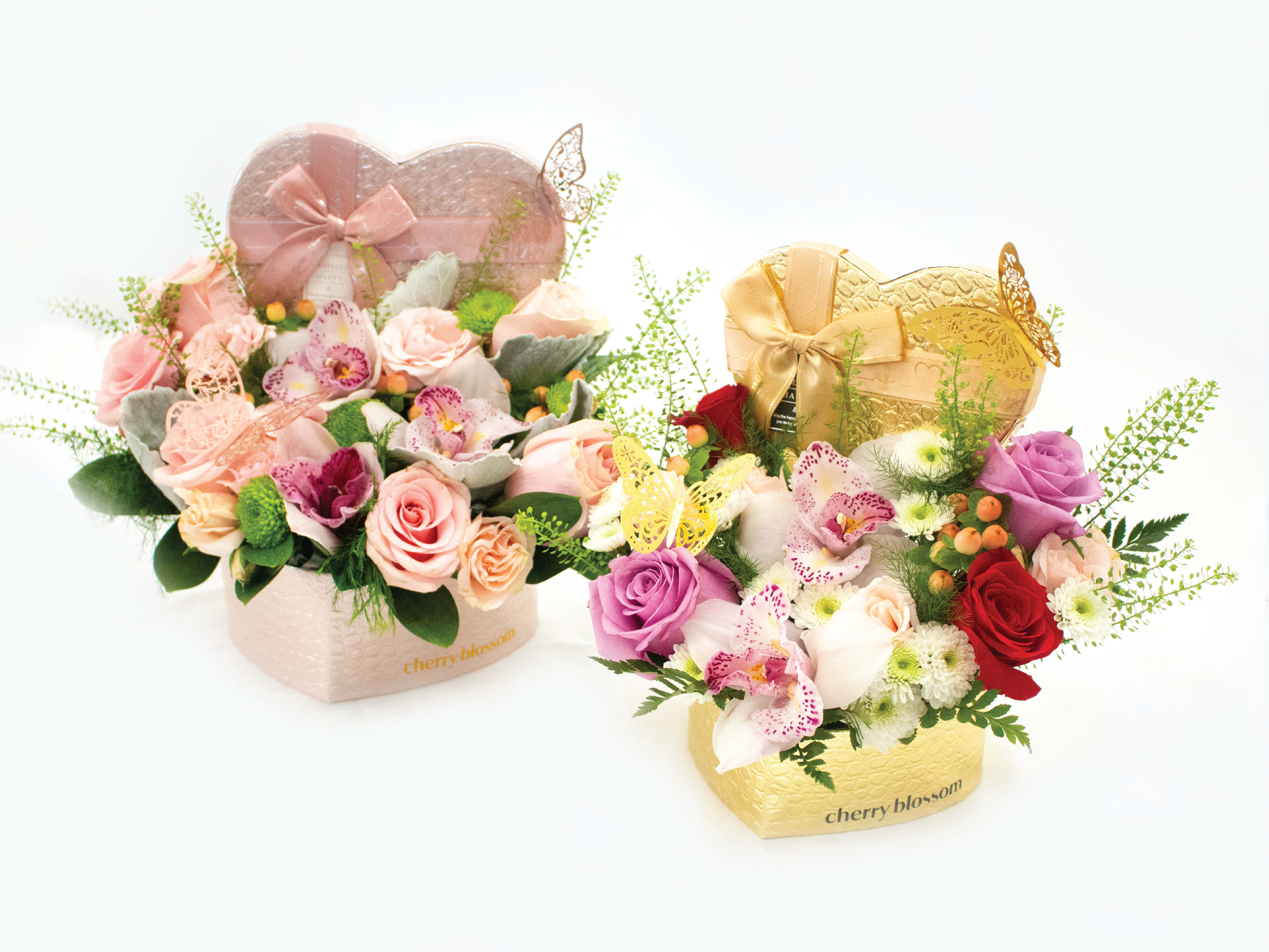 Two heart-shaped floral gift boxes with roses and orchids